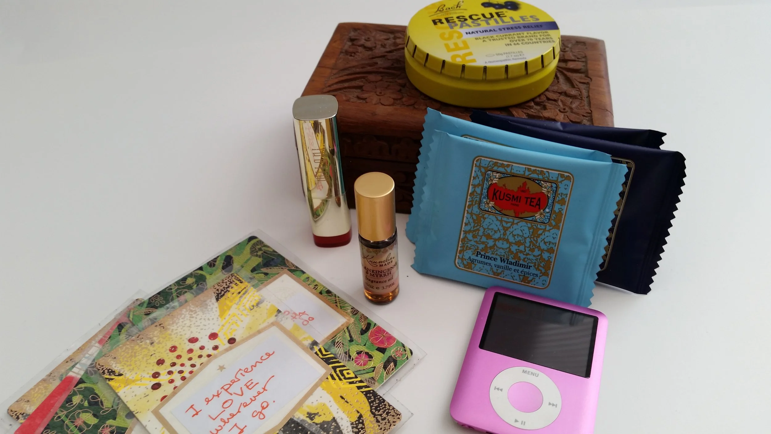 My sadness-interrupting happiness treasure chest for those tough days. Clockwise from top: Rescue Remedy lozenges, Kusmi teabags in Prince Vladimir and Anastasia, an old ipod (pink!) that holds only my happy songs and happy videos, homemade affirmation cards which I've laminated, Frankincense & Myrrh rollerball essential oil, my favorite drugstore lipstick, and the rosewood box in which I keep all of these items.