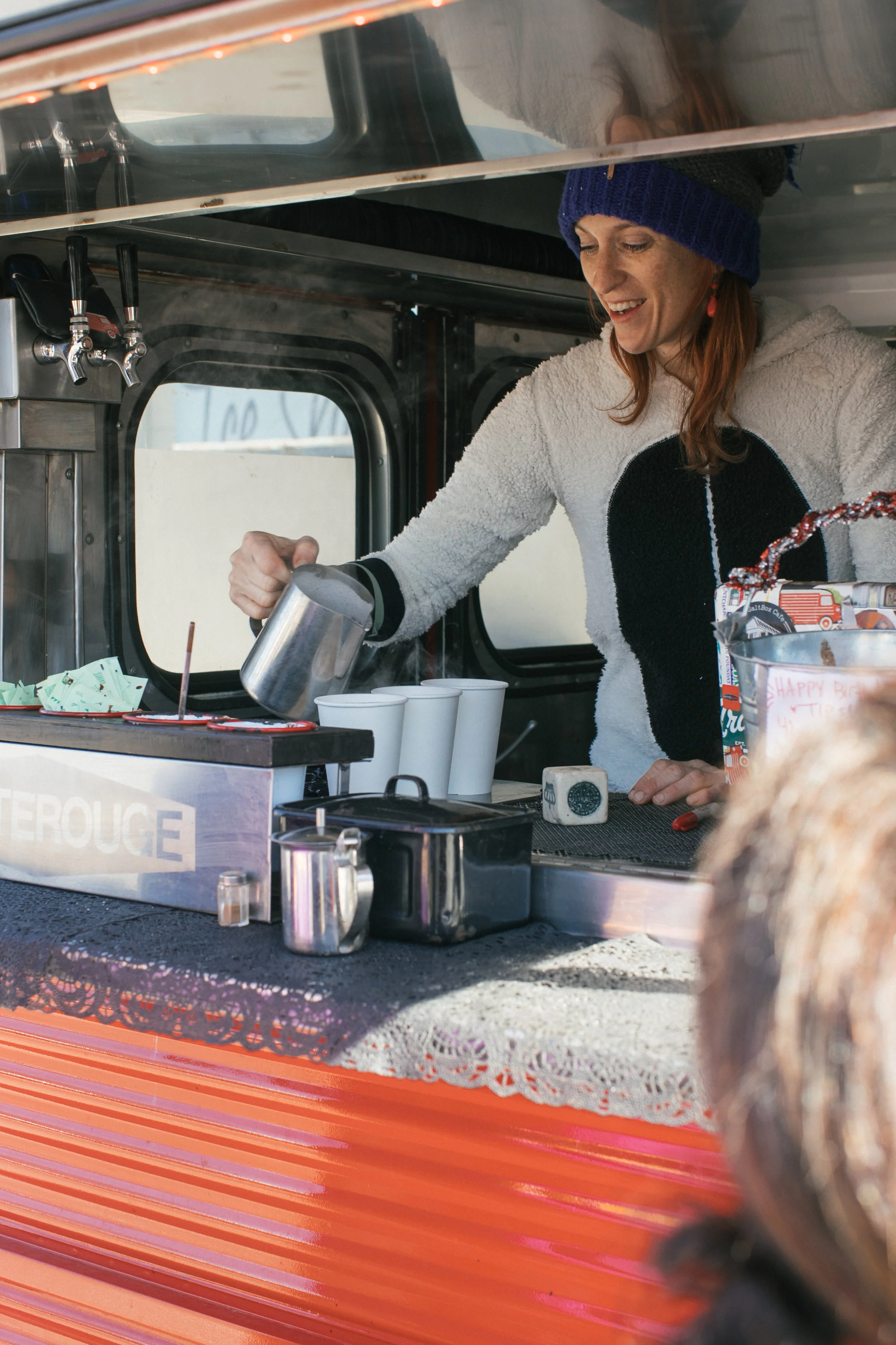 Julie of NOLA-based Petite Rouge Coffee wears a onesie and pours specialty espresso drinks from her vintage 1970 Citroen H-Van. OA