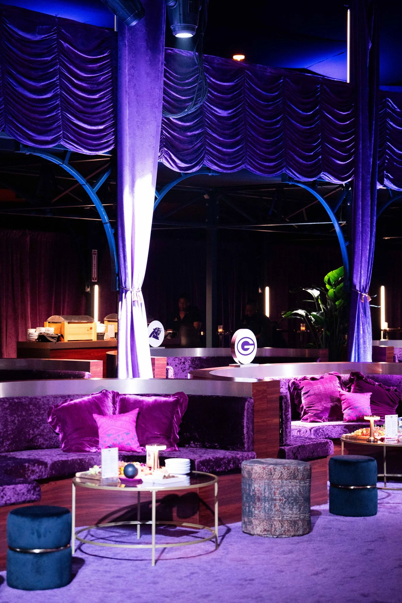 Outdoor Commissioner’s Party lounge with purple lighting and seating.