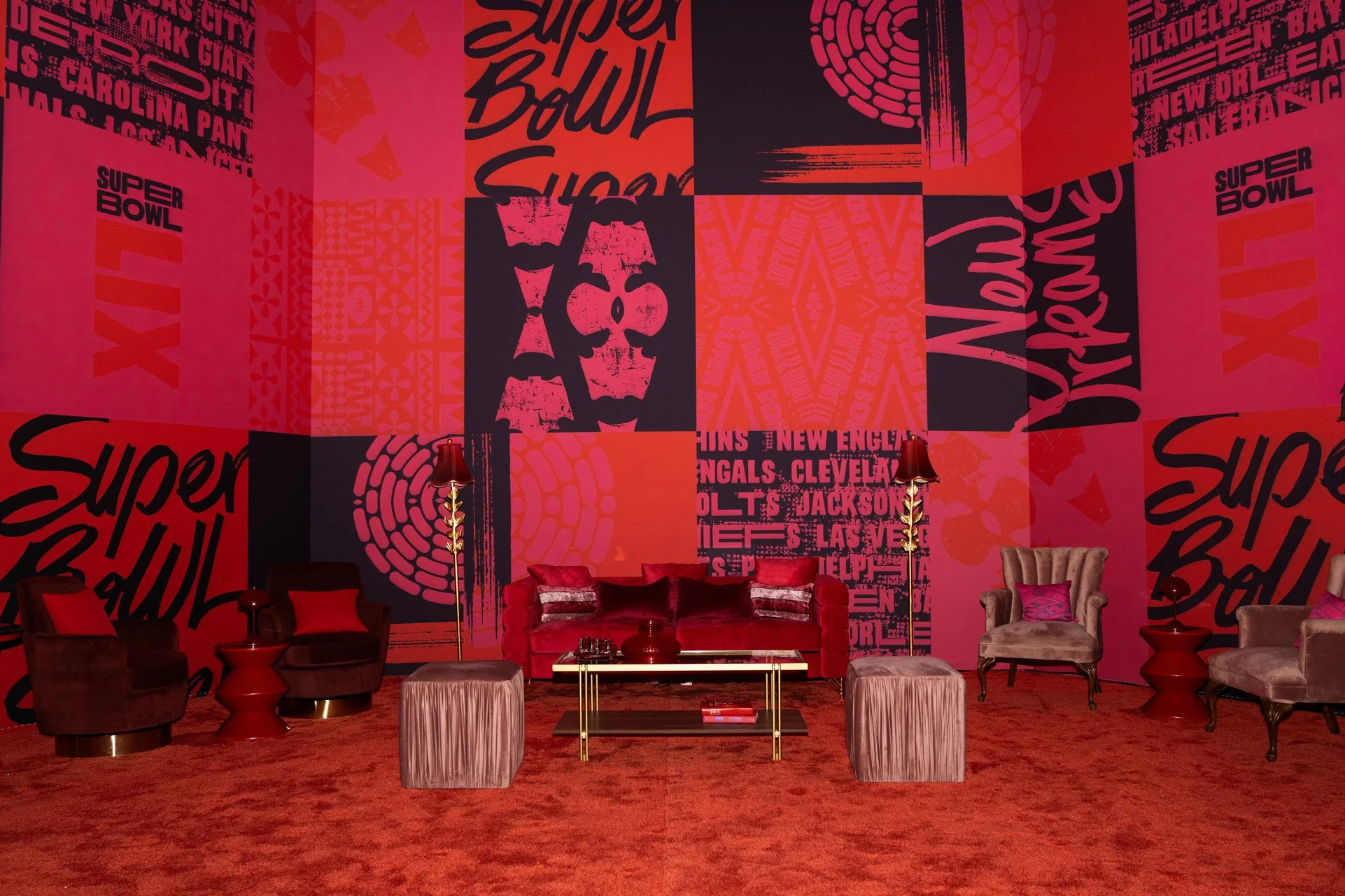 Red event lounge with graphic wall coverings and casual seating.