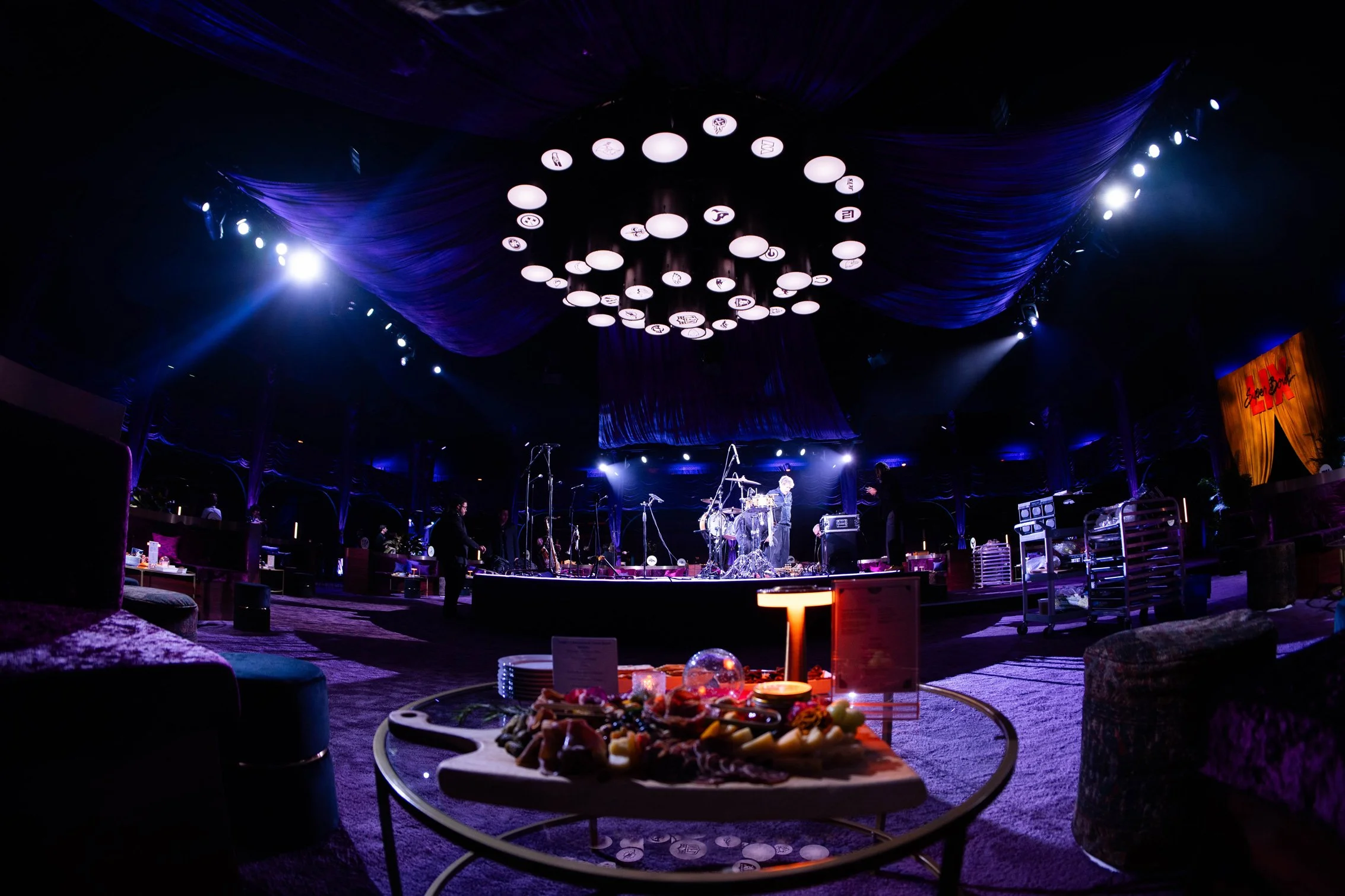 Commissioner’s Party event space with circular lounge seating and overhead lighting installation.