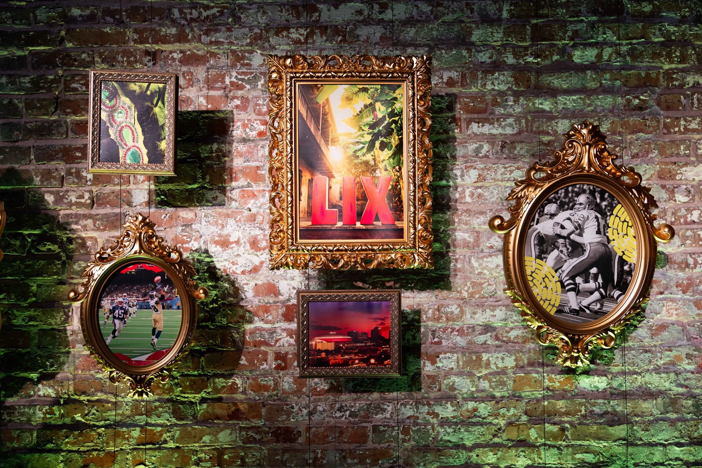 Framed artwork displayed against a greenery wall with floral accents.
