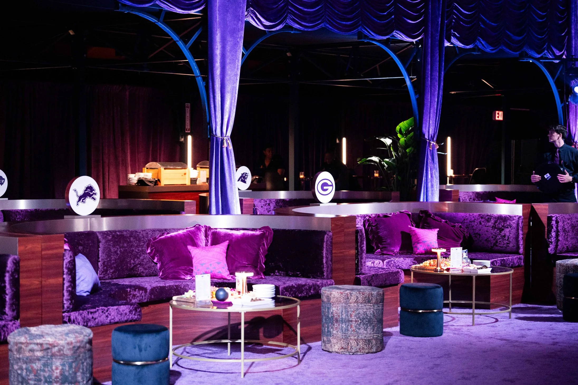 Outdoor lounge setup with illuminated trees and colorful furnishings.