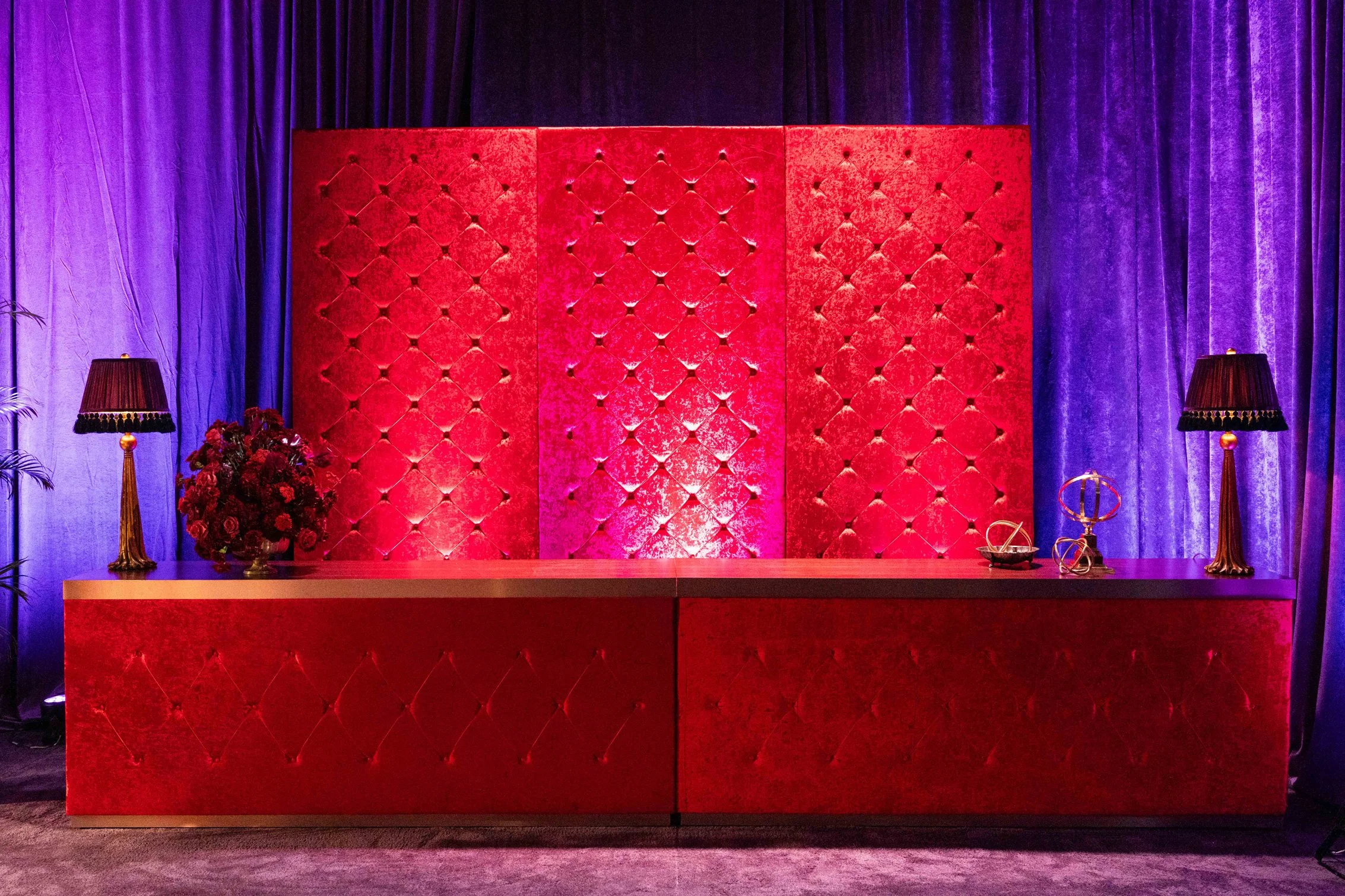 Red tufted event bar with purple lighting at the NFL Commissioner’s Party.