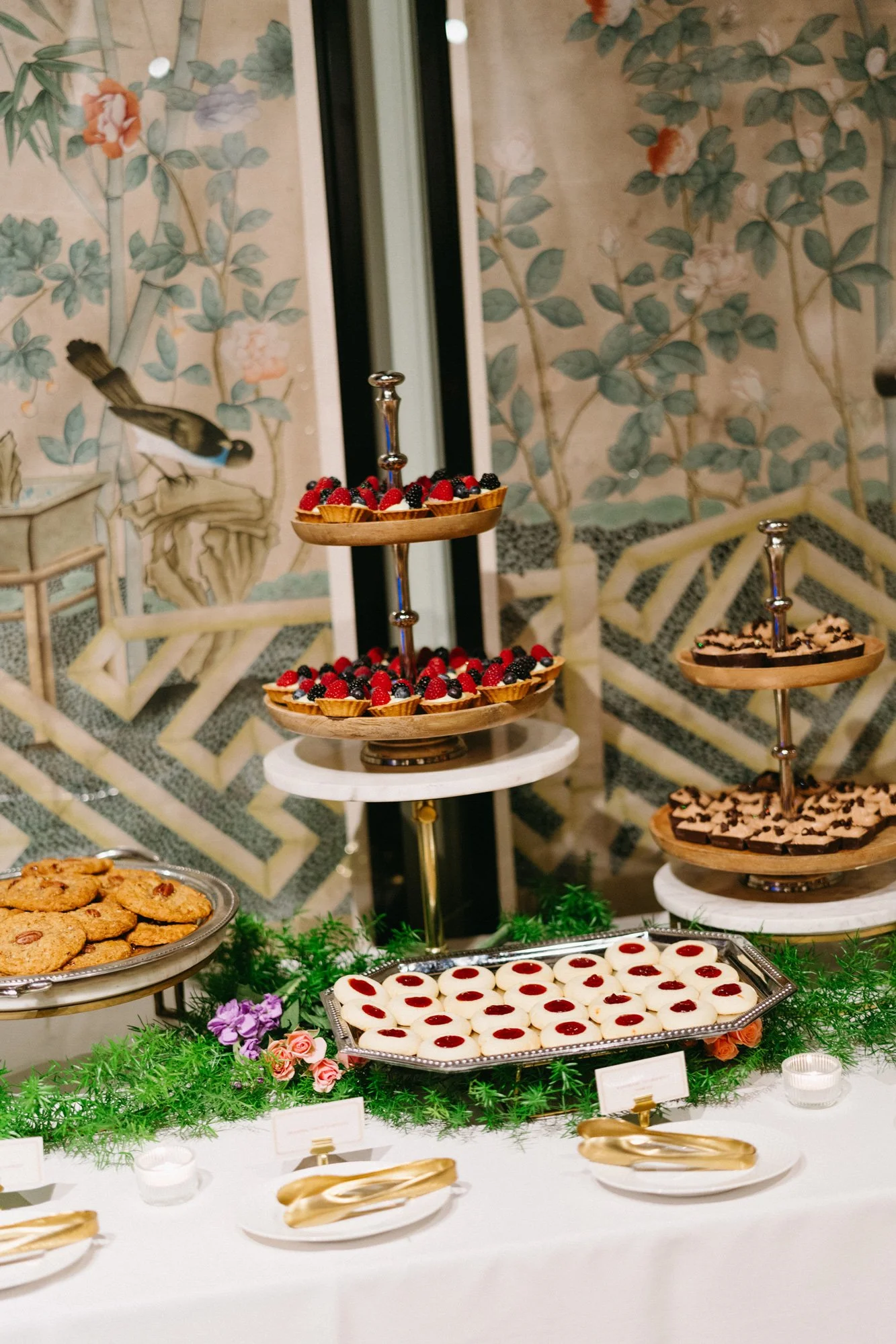 Dessert table with tiered stands and assorted sweets.
