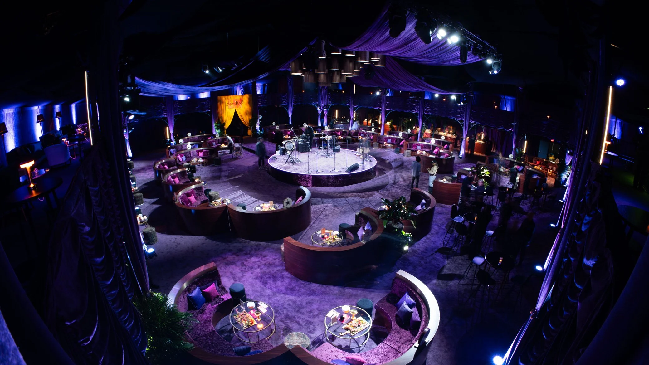 Reception area with circular tables and suspended greenery.