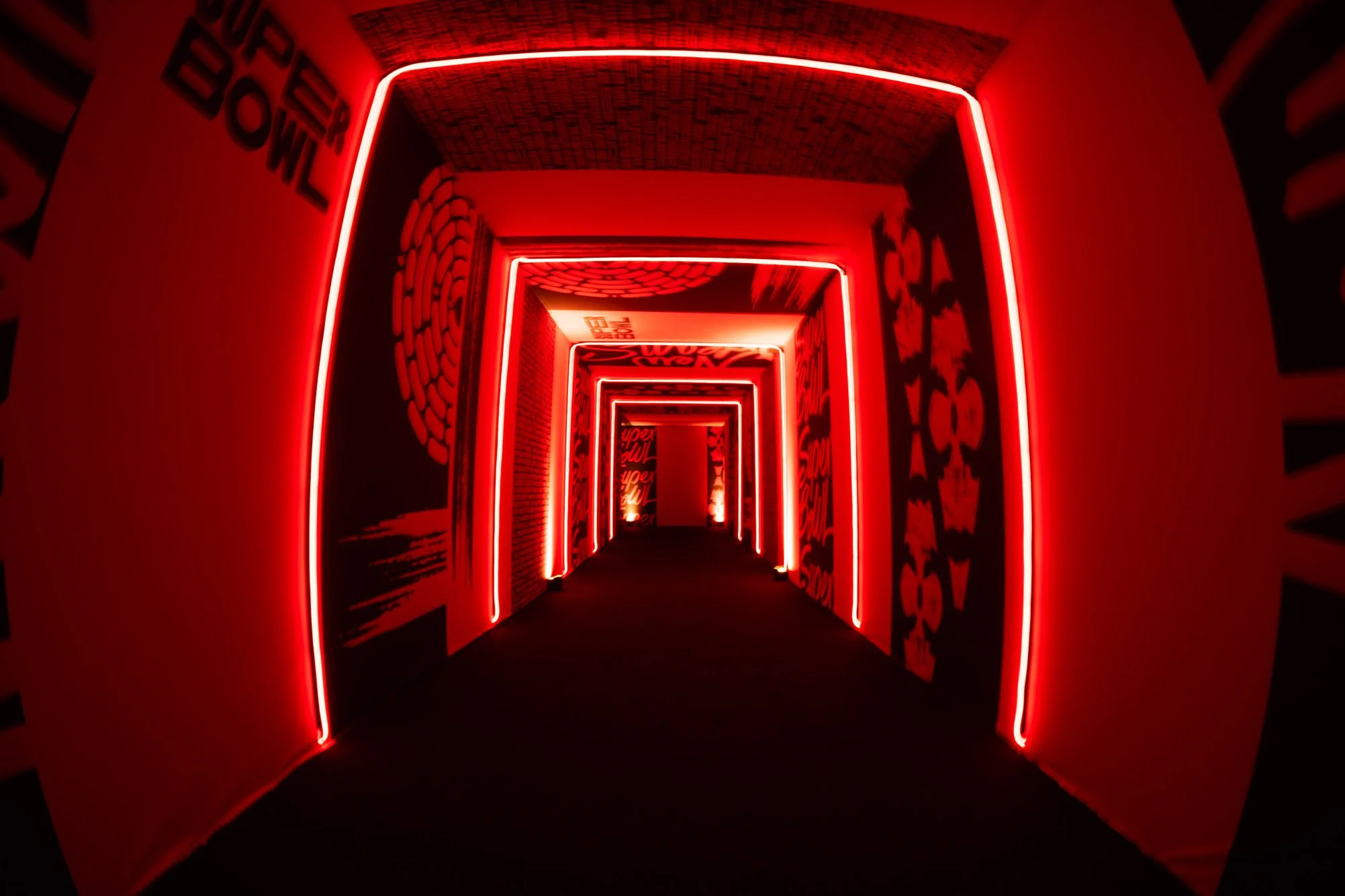 Red illuminated entrance tunnel with repeating archways.
