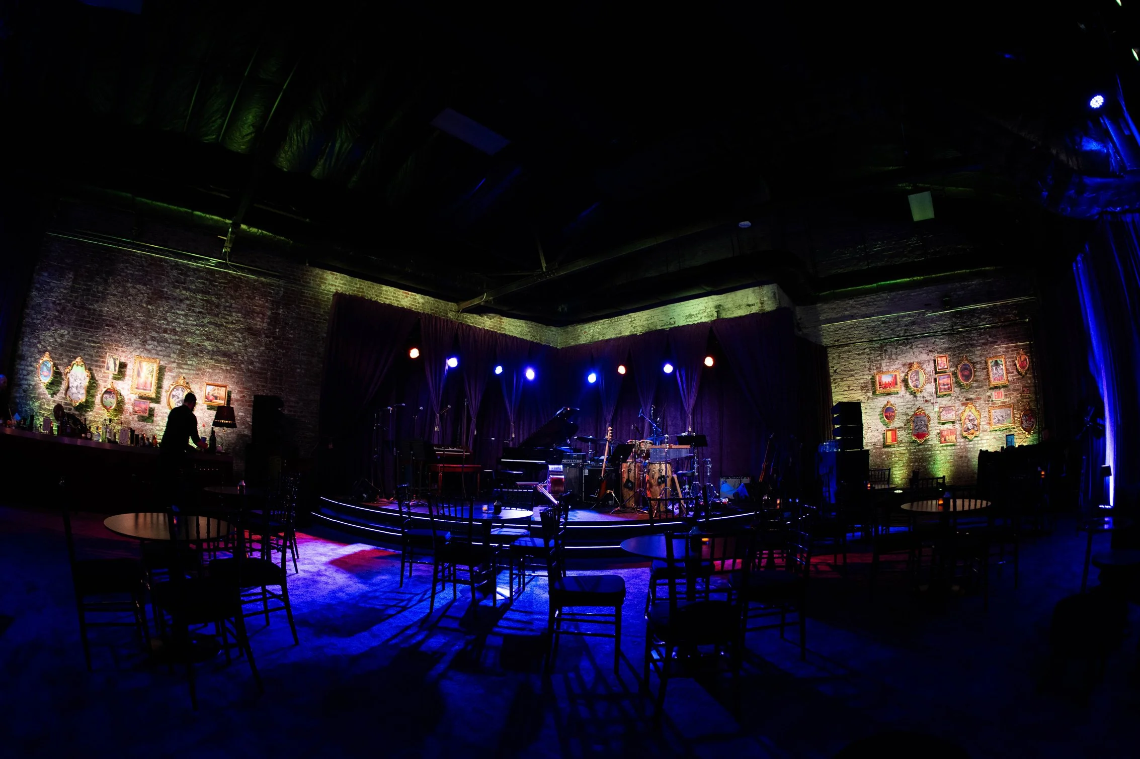 Event lounge with blue lighting and suspended greenery.