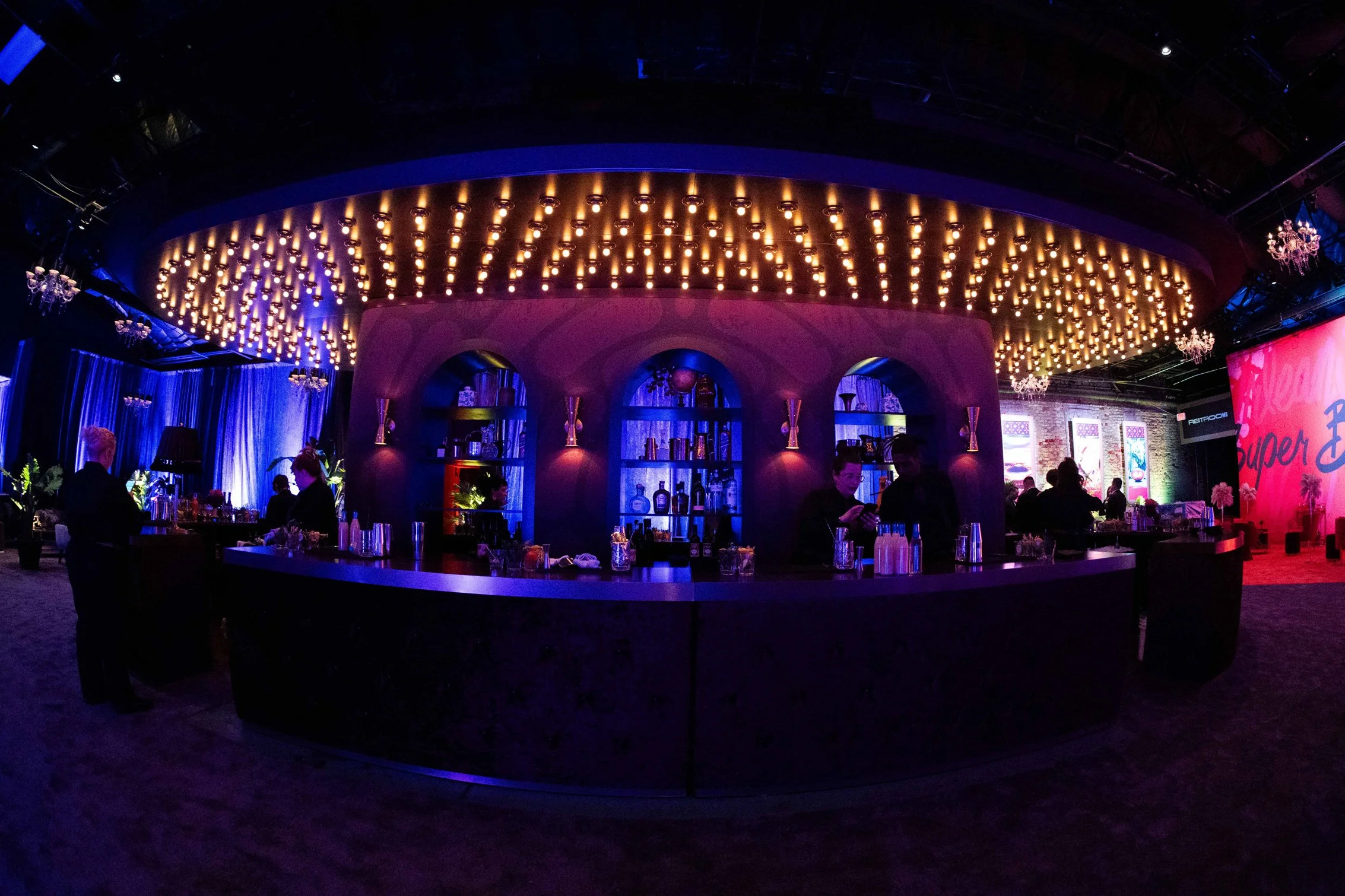 Circular event bar illuminated with purple and blue lighting.