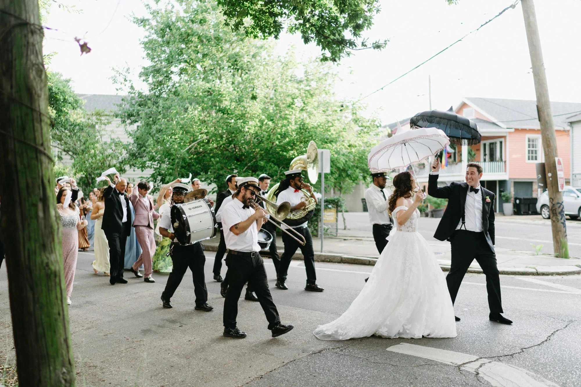 Missy and Alec celebrating with a brass band and wedding guests.