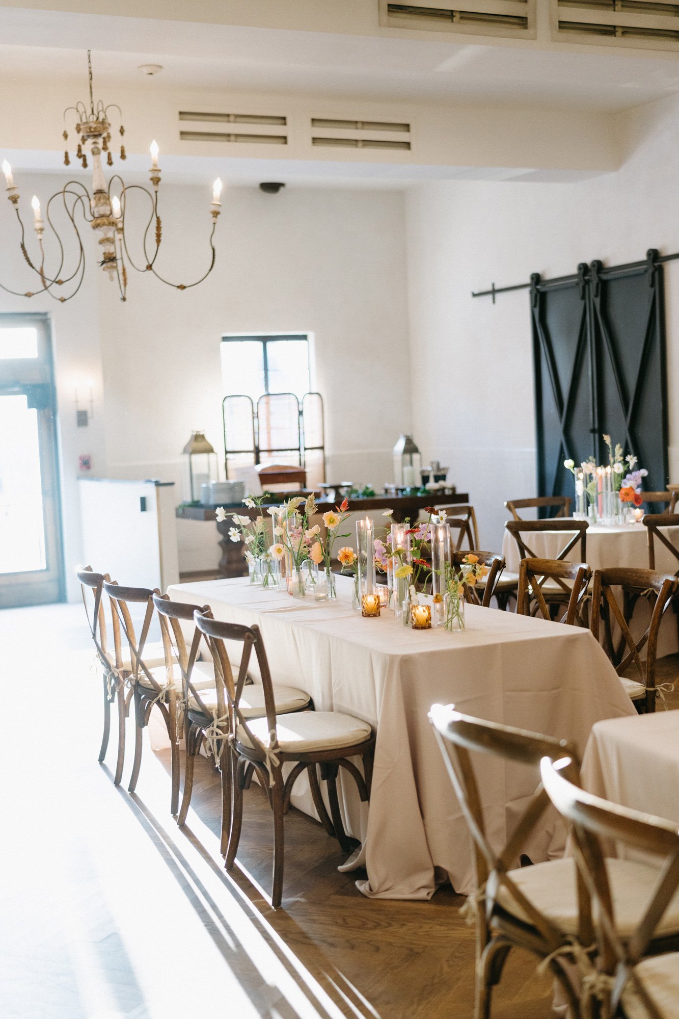 Indoor reception tables set for wedding guests.