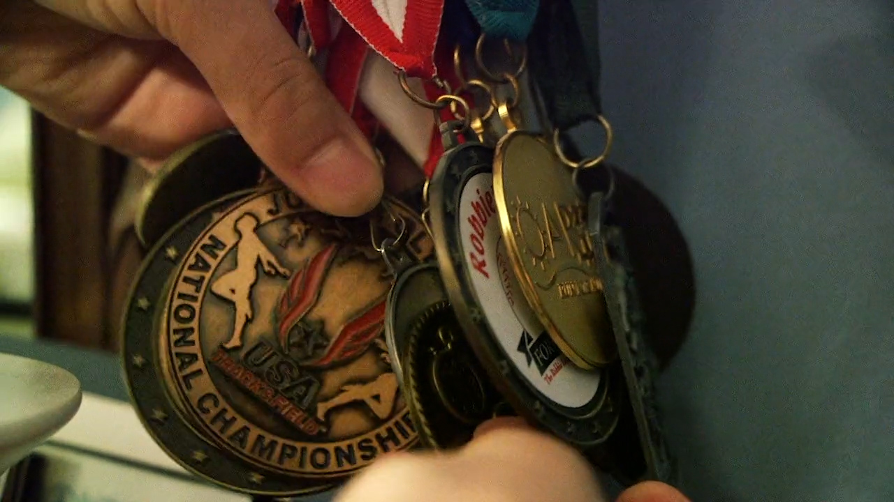 Marathon Men_Thomas showing medals .jpg