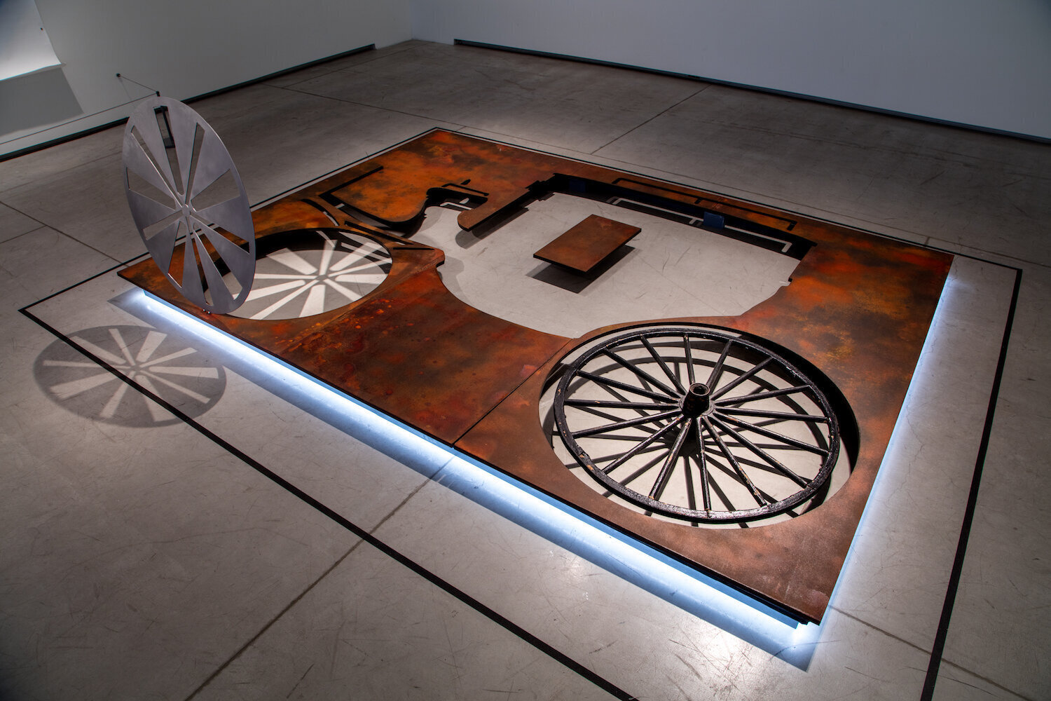    A Mobile and Visible Carriage,   Charmaine Lurch, 2017 (installation view), MDF painted with metal based paint, stainless steel, antique wheel, wood, LED Light, 10’x11’ 