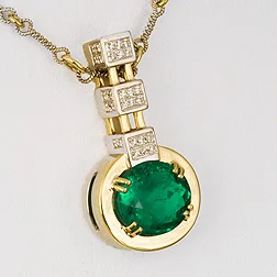 Eighteen karat two tone necklace featuring a 4.95-carat oval emerald (oil & resin) prong set with 0.23-carat diamonds on a handmade two tone chain. See Inv. #17858 .