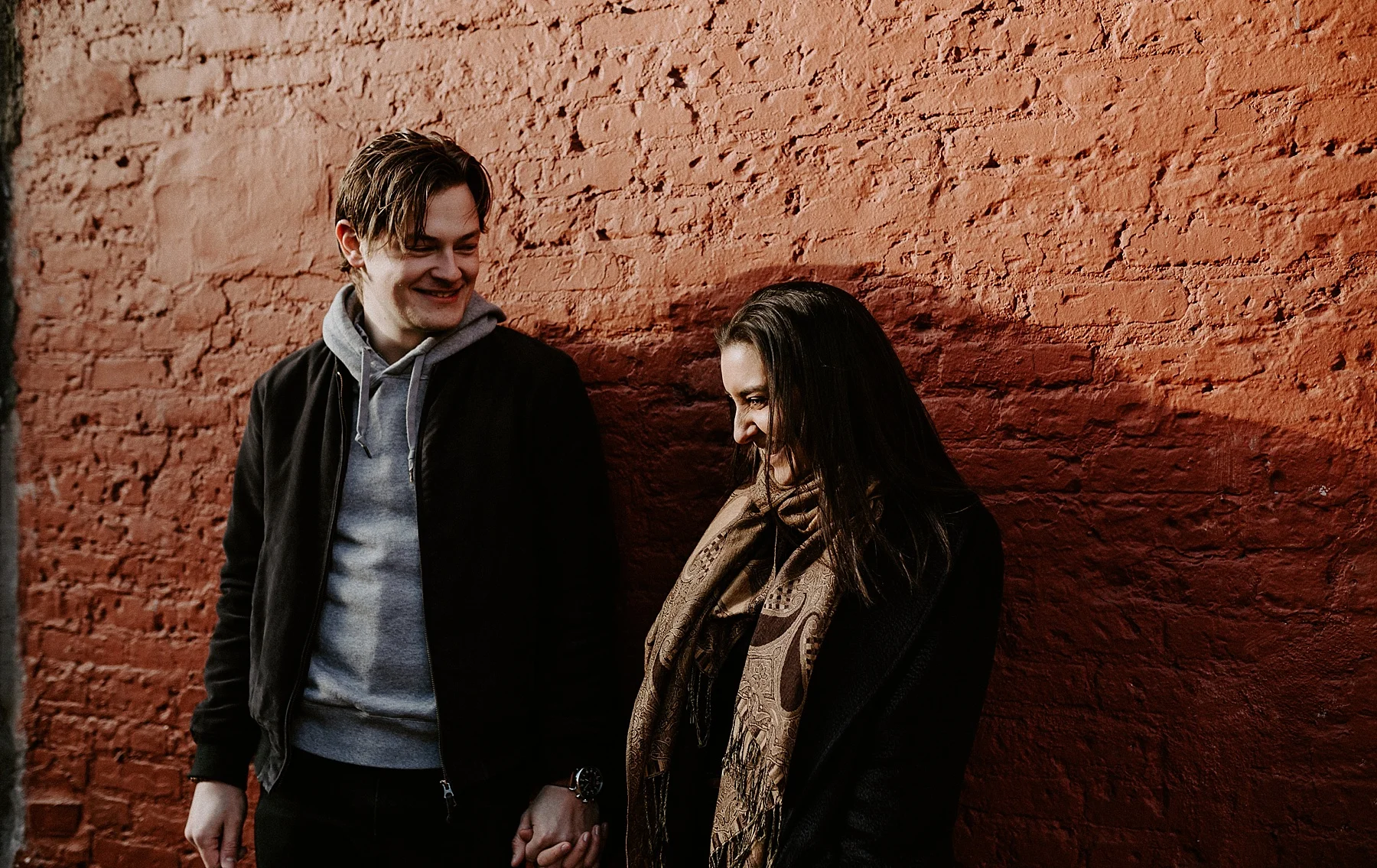Couple telling each other jokes and laughing during engagement session on the streets of New York City