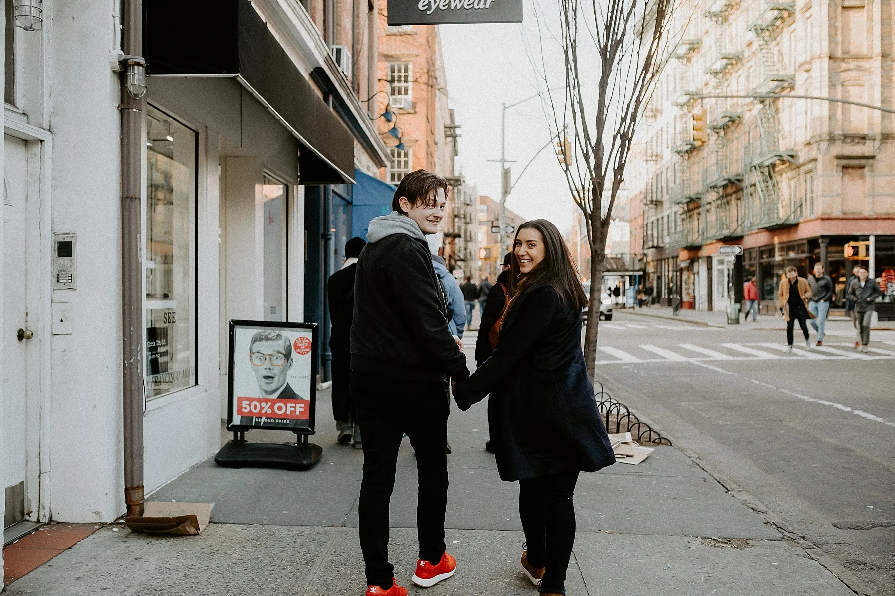 Walking on the streets of New York City while holding hands during engagement session