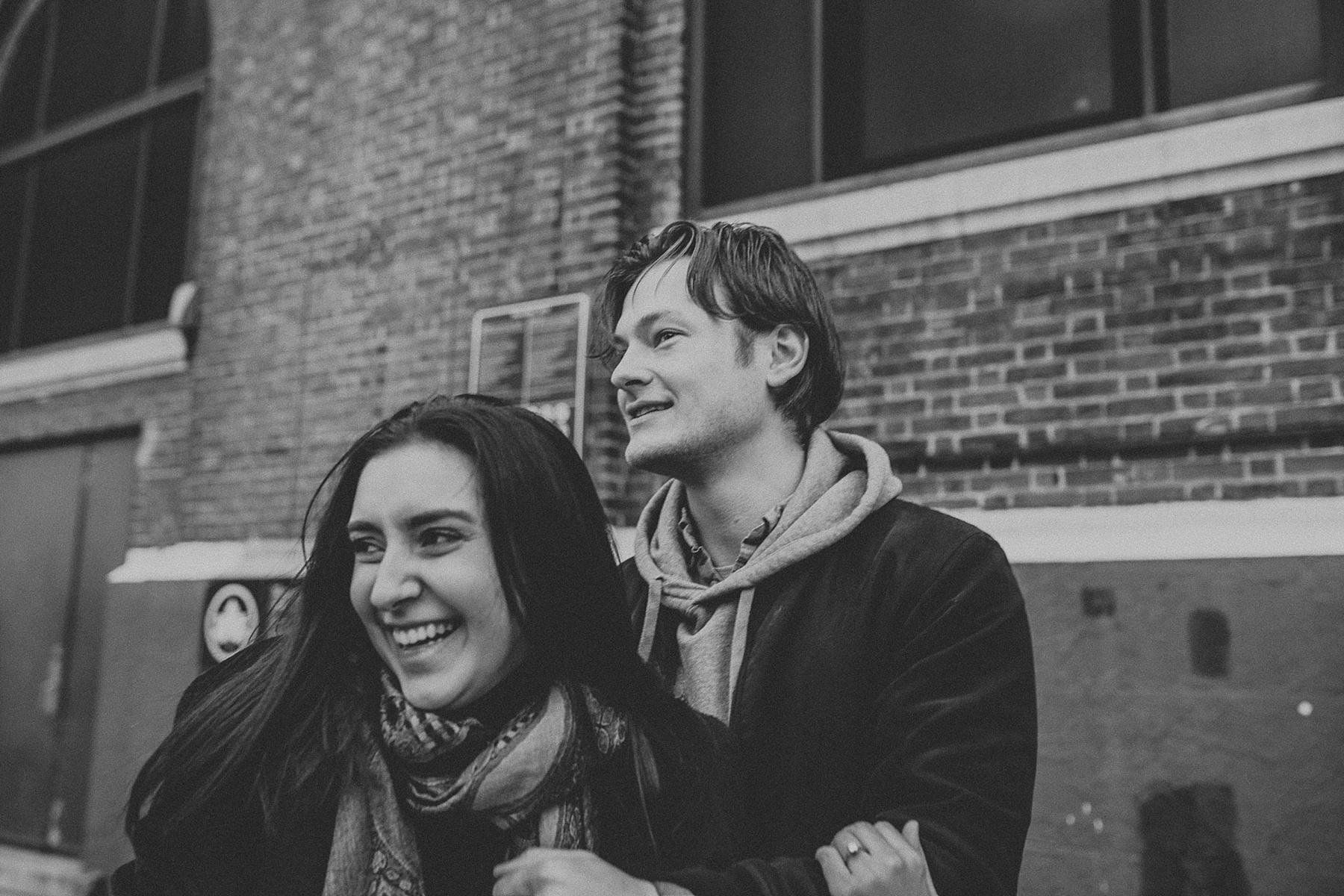 Couple having a sweet and fun moment bumping into one another during engagement session in New York City, New York