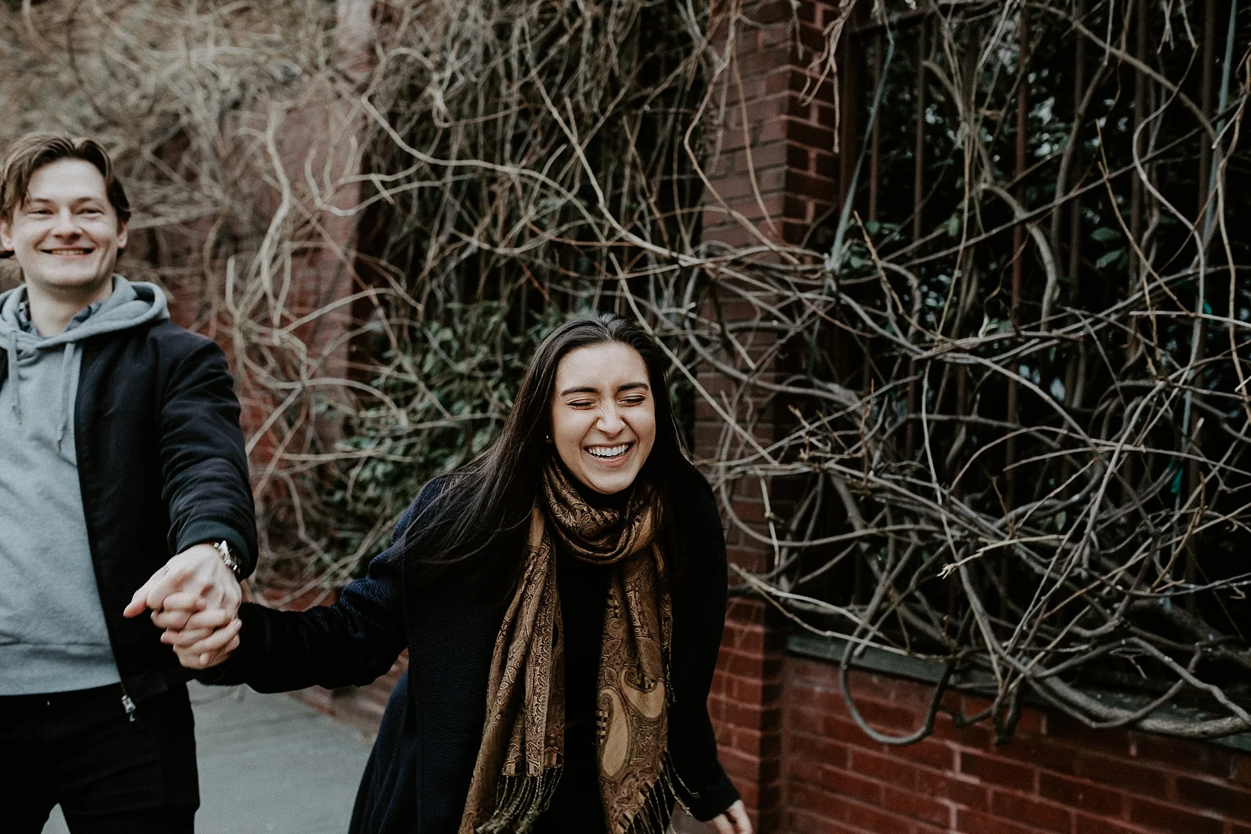 Dancing and frolicking while holding hands during engagement session in New York City