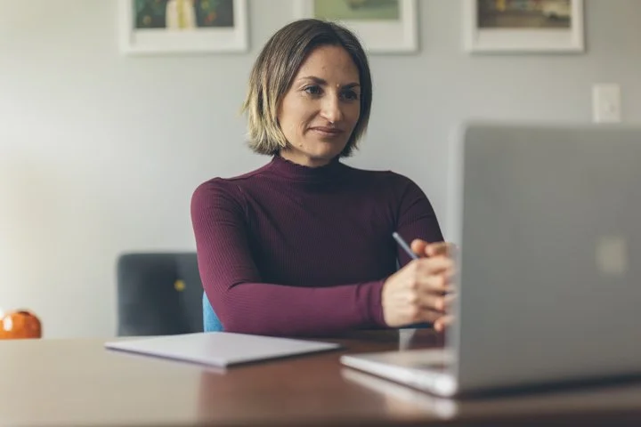 Person watching emetophobia FAQ video on laptop getting questions about recovery answered by specialists