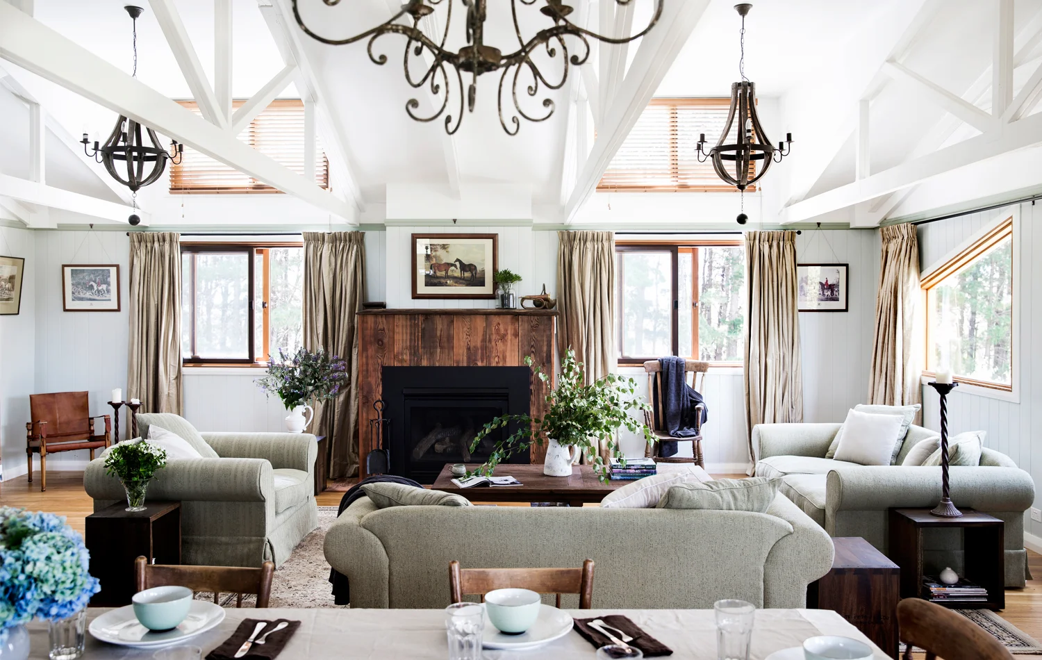 Exposed rafters are a reminder of the home’s origins – the timber chandeliers from OneWorld Collection bring a touch of glamour to the space.