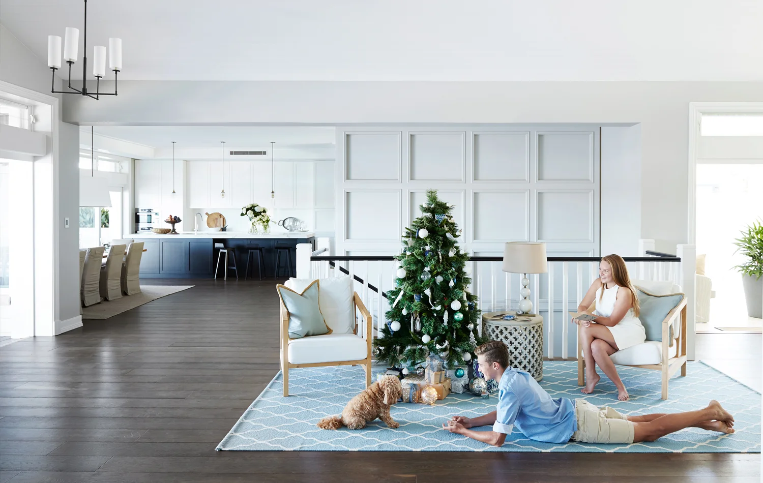 The stairs and one wall are all that remain of the original home. Furniture placement and rugs demarcate zones in this open-plan space, with the selective use of detailed panelling creating a sense of intimacy. Teenagers Declan and Taylor, with cavoodle Bolli, enjoy the build up to Christmas Day.