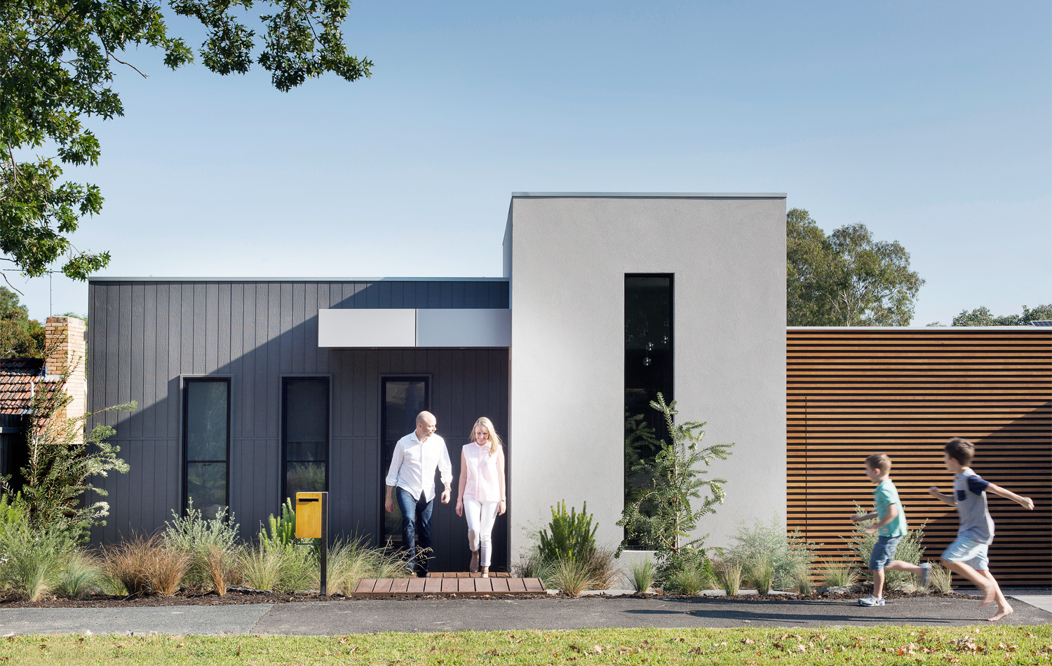 Homeowners Craig and Megan Bates with their sons Ethan (left) and Campbell. Their new home presents a modern face to the street. photography Martina Gemmola