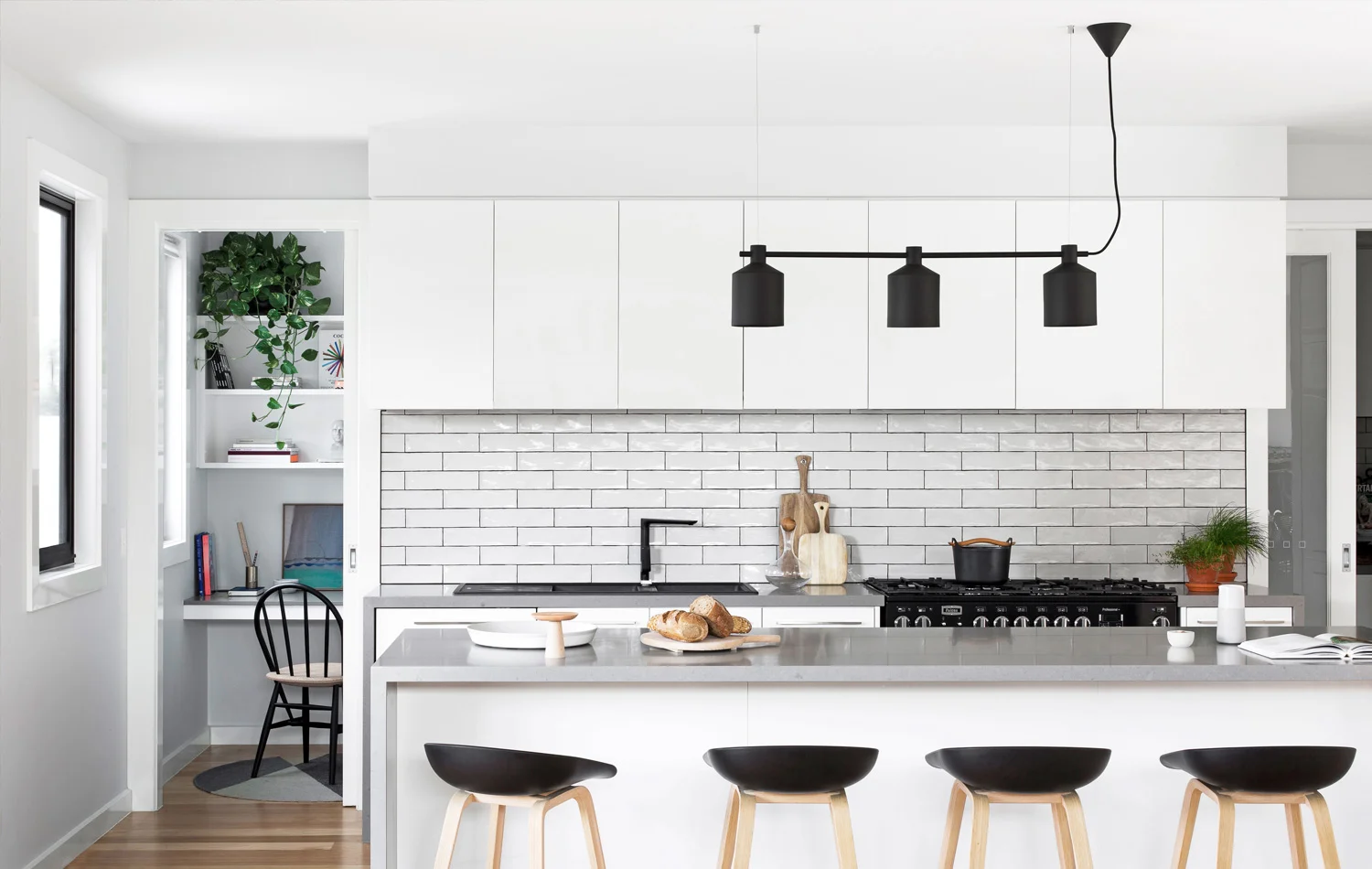 A compact study is concealed behind a sliding door in the kitchen.