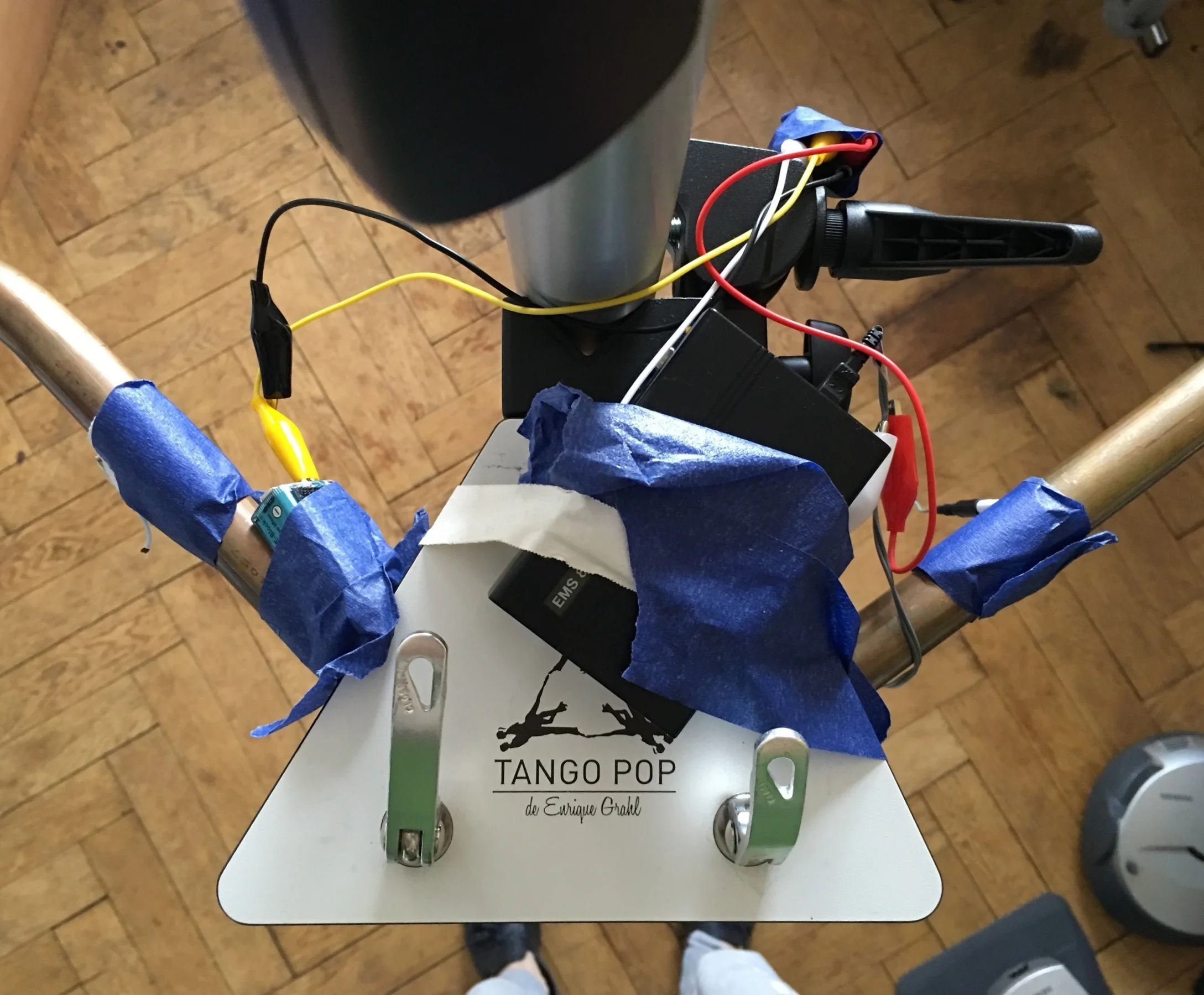 Der erste elektrifizierte Tango Pop Trainer Unser Versuchsaufbau: ein völlig ungefährlich es EMS Gerät zur Schmerztherapie gekoppelt mit den beiden kupfernen Handgriffen überträgt die Strom Impulse abhängig von der Musik auf den Probanden. 
