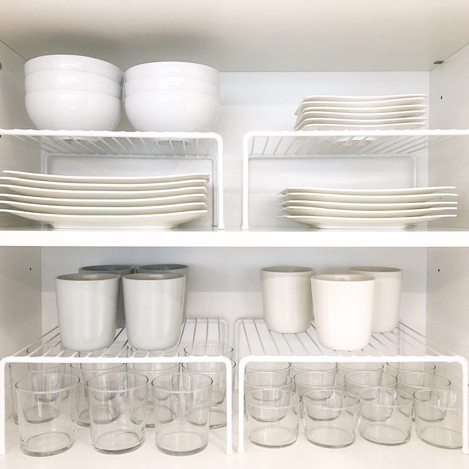 White kitchen cabinet organized with shelf risers