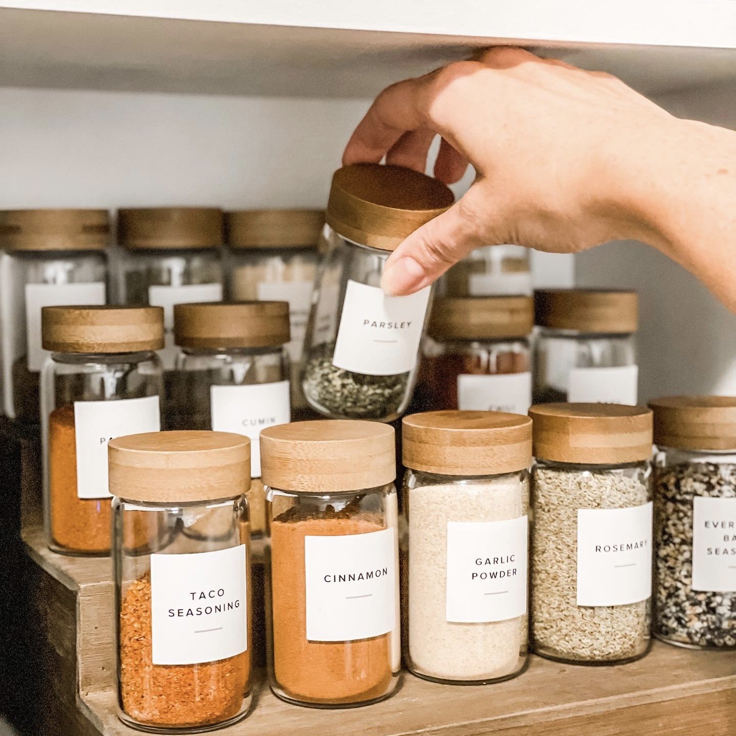 Multi step spice rack with labeled glass spice jars