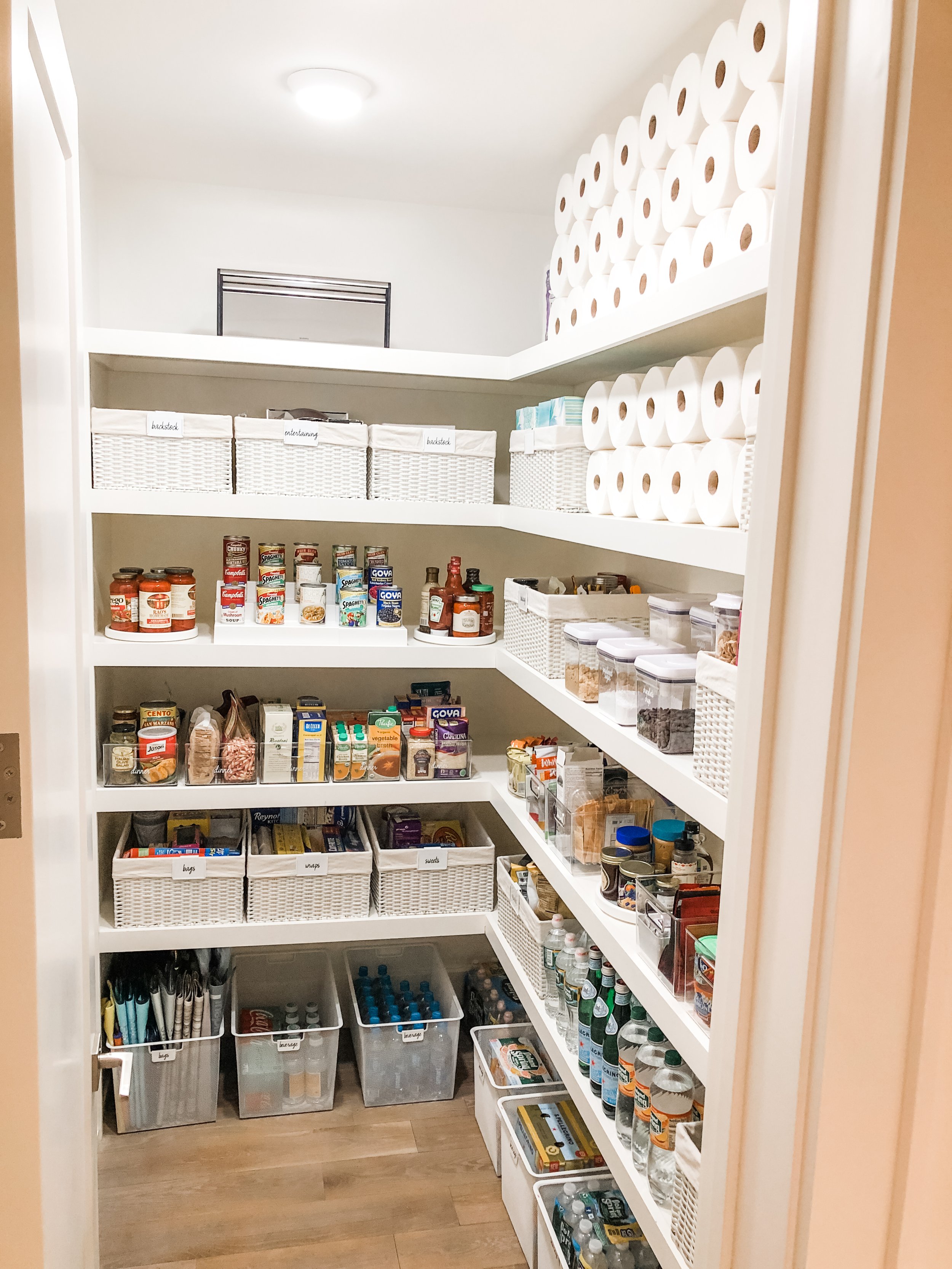Kitchen walk-in pantry fully organized with bins, containers, and baskets