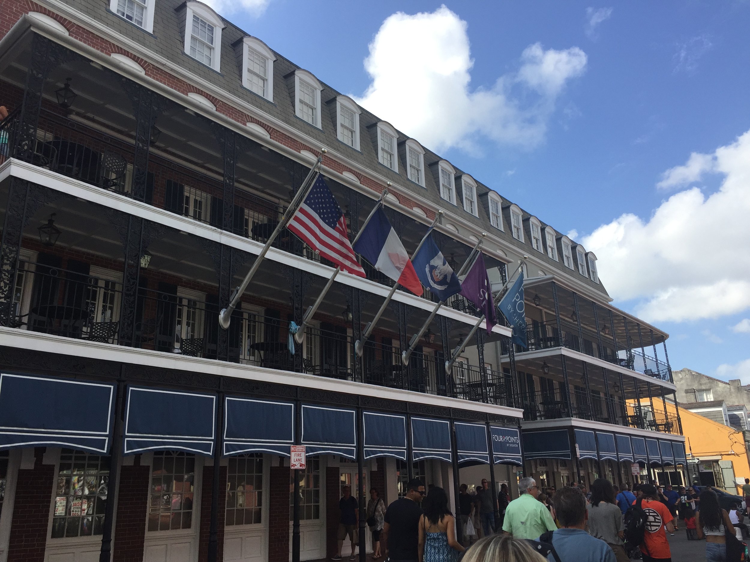  America,&nbsp;France, and Louisiana. All three flags displayed together on the famous Bourbon St. outside of a nice hotel. 