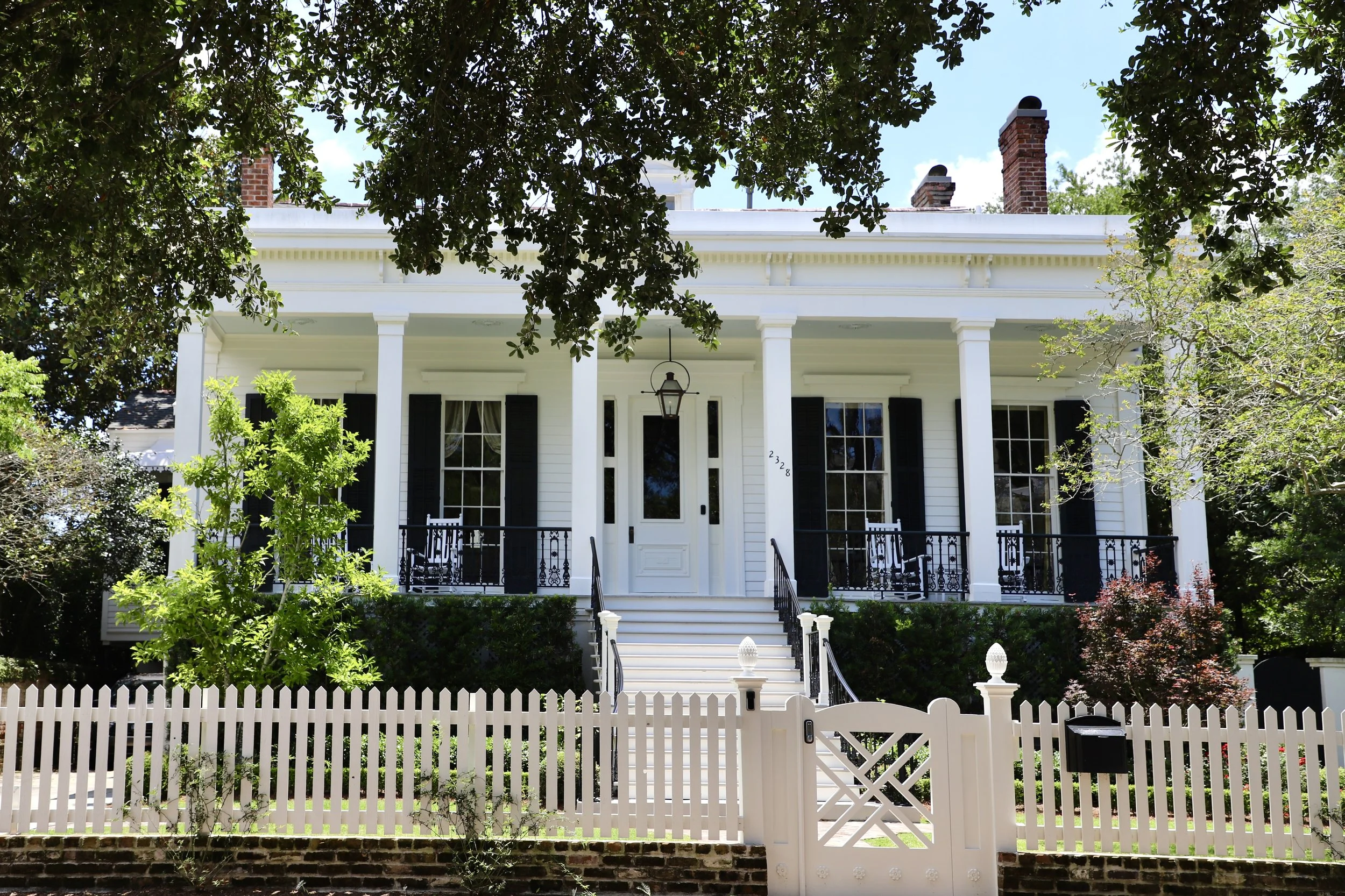  A plantation style home stands guarded by a white picket fence in the Garden District of New Orleans. The Garden District is known as the wealthy neighborhood of New Orleans since the 19th century.  
