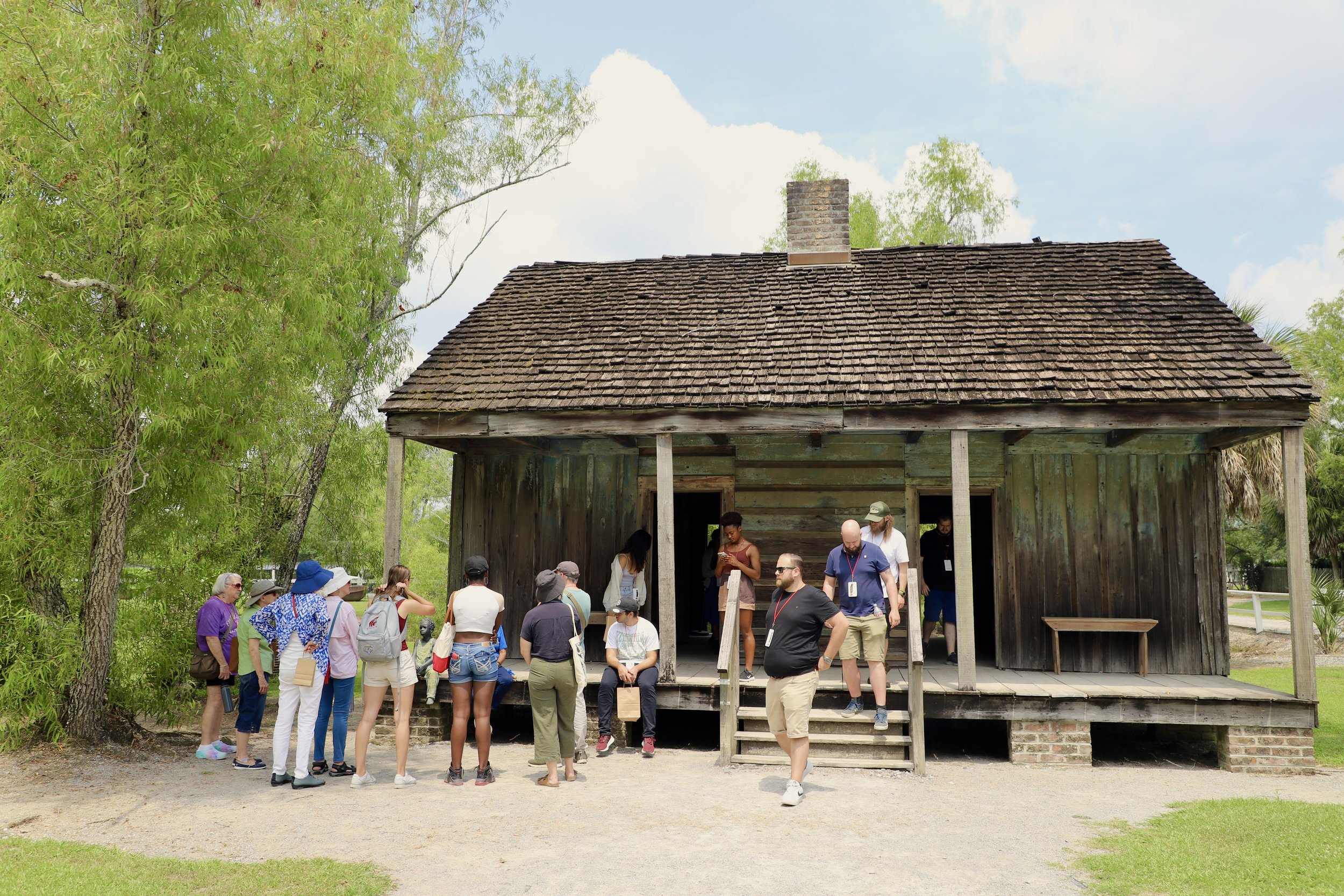  The students clamor around the tour guide to learn the history of the Whitney Plantation. This portion of the tour gave students the opportunity to look into a slave cabin and what life was like for people of enslavement.  