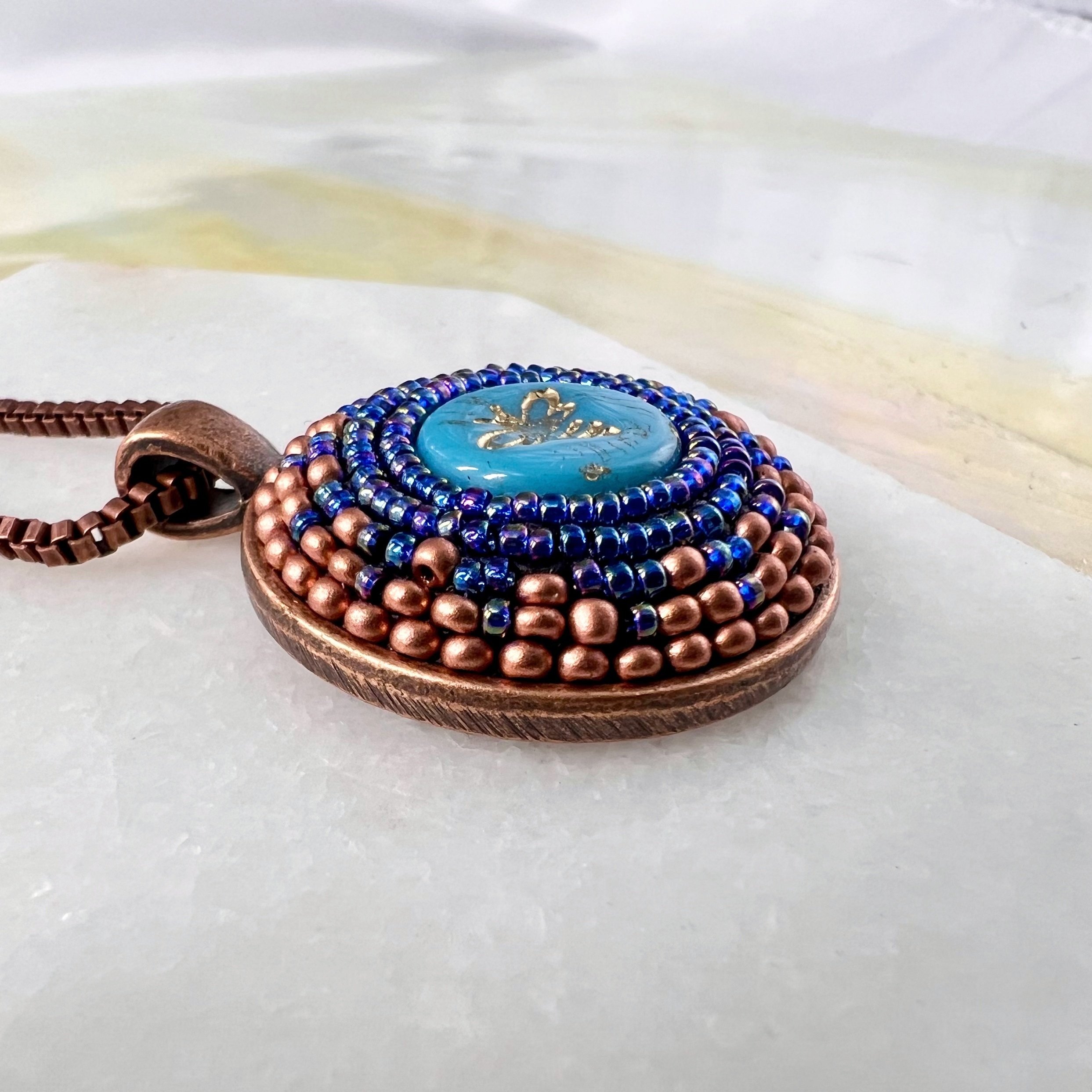 Side view of bee mosaic pendant by artist Dyanne Williams.