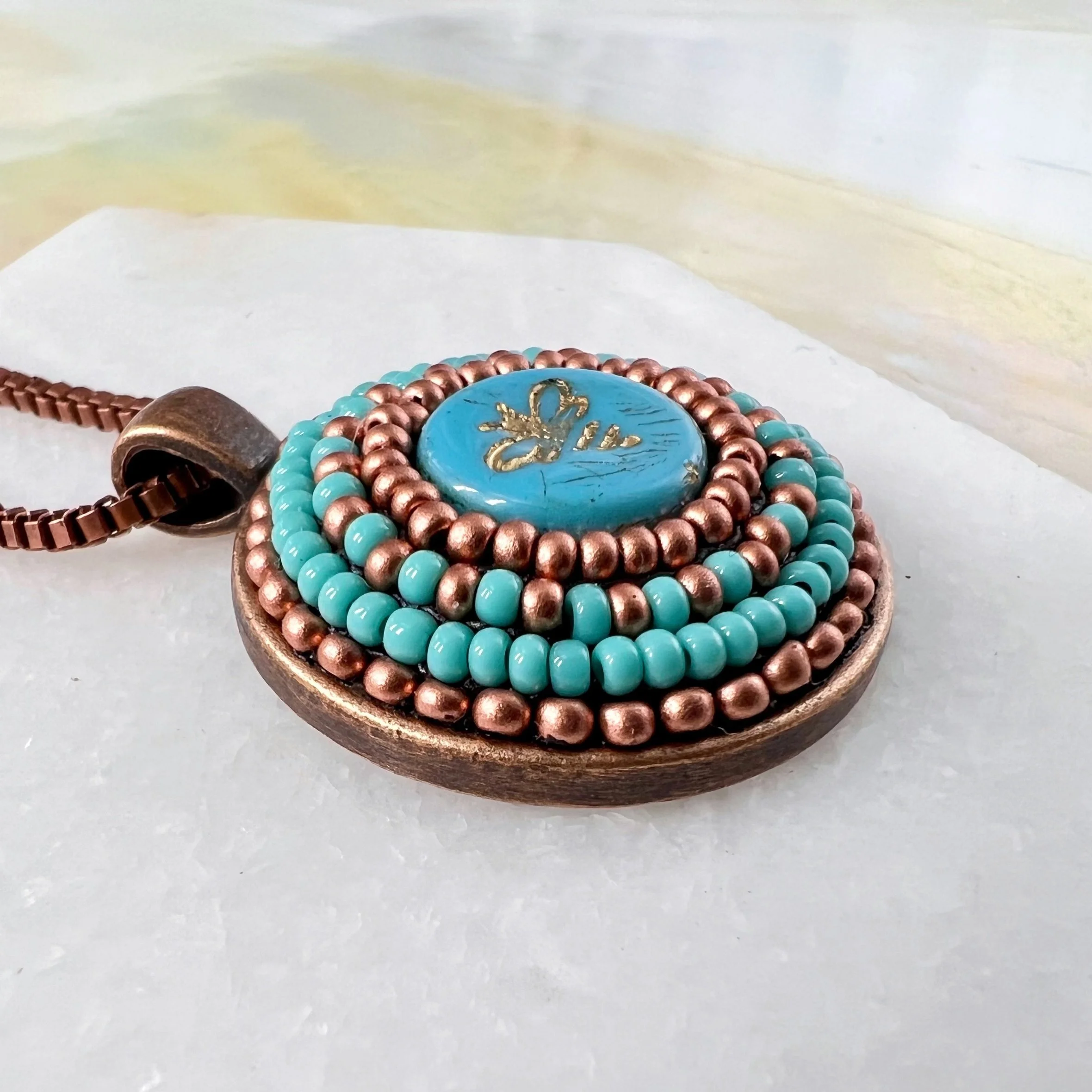 Side view of bee mosaic pendant by artist Dyanne Williams.