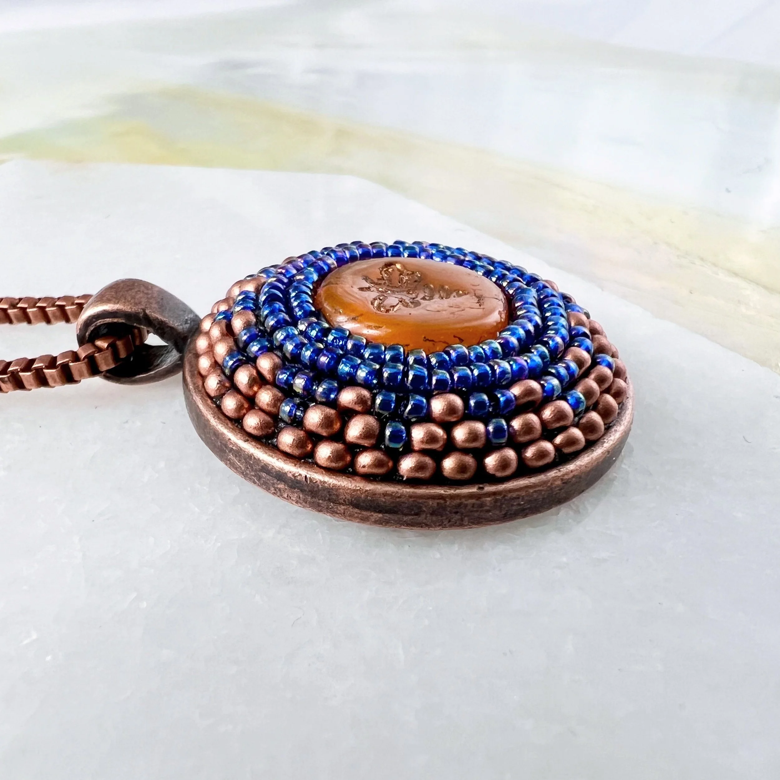 Side view of bee mosaic pendant by artist Dyanne Williams.