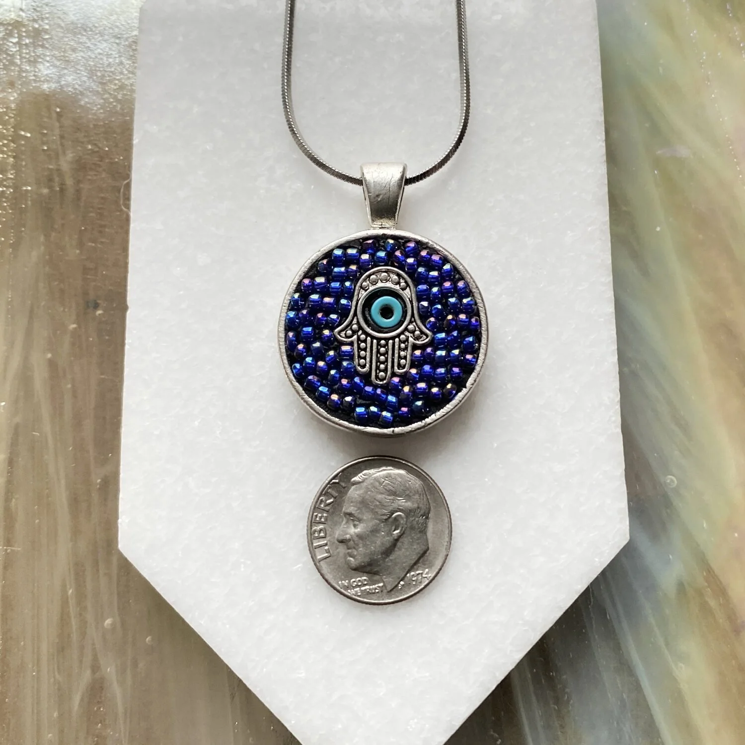 Mosaic pendant by artist Dyanne Williams next to dime for size reference.