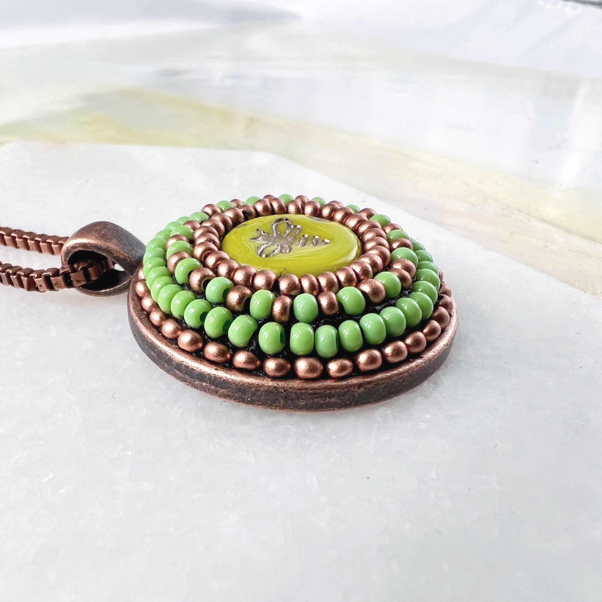 Side view of bee mosaic pendant by artist Dyanne Wiliams