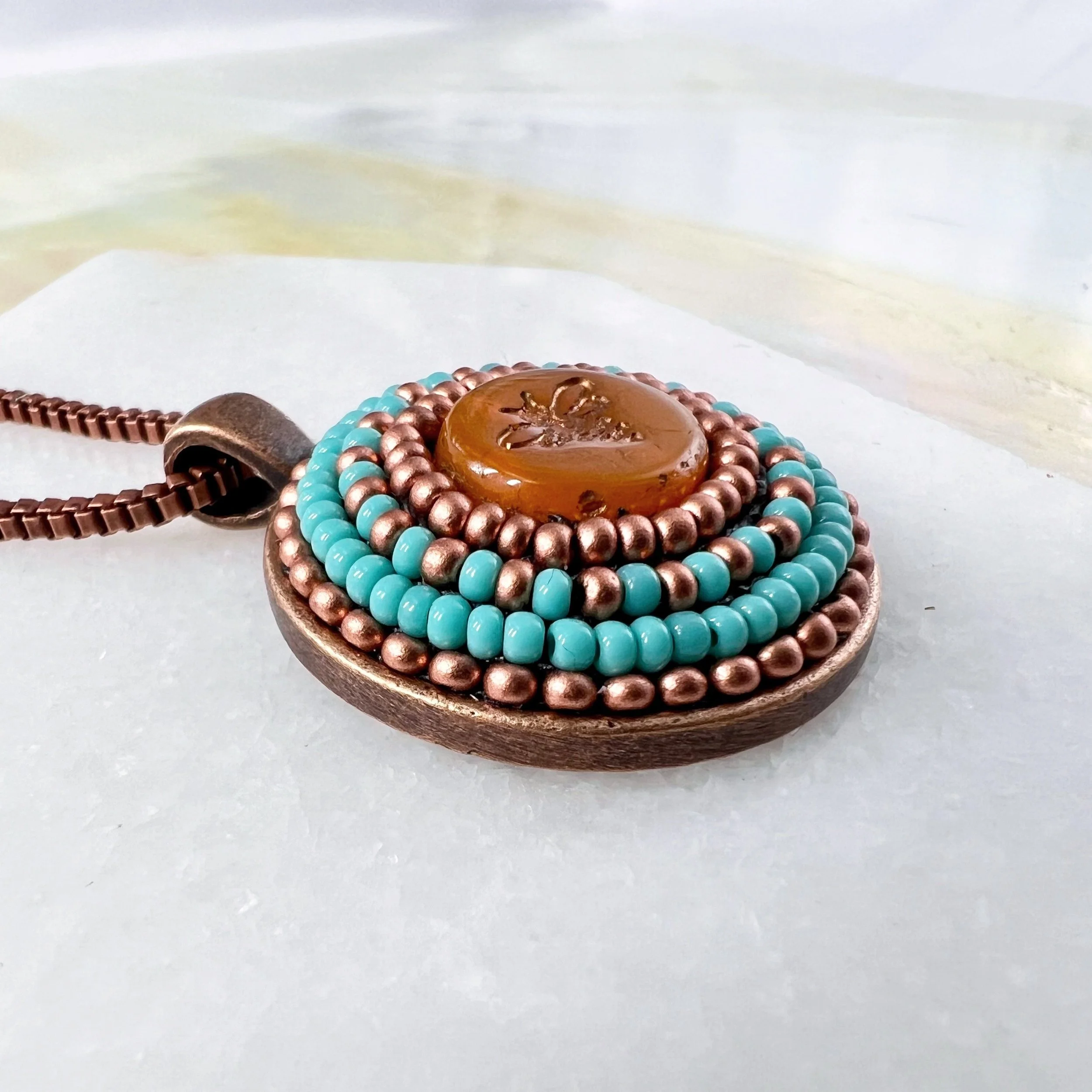 Side view of bee mosaic pendant by artist Dyanne Williams.
