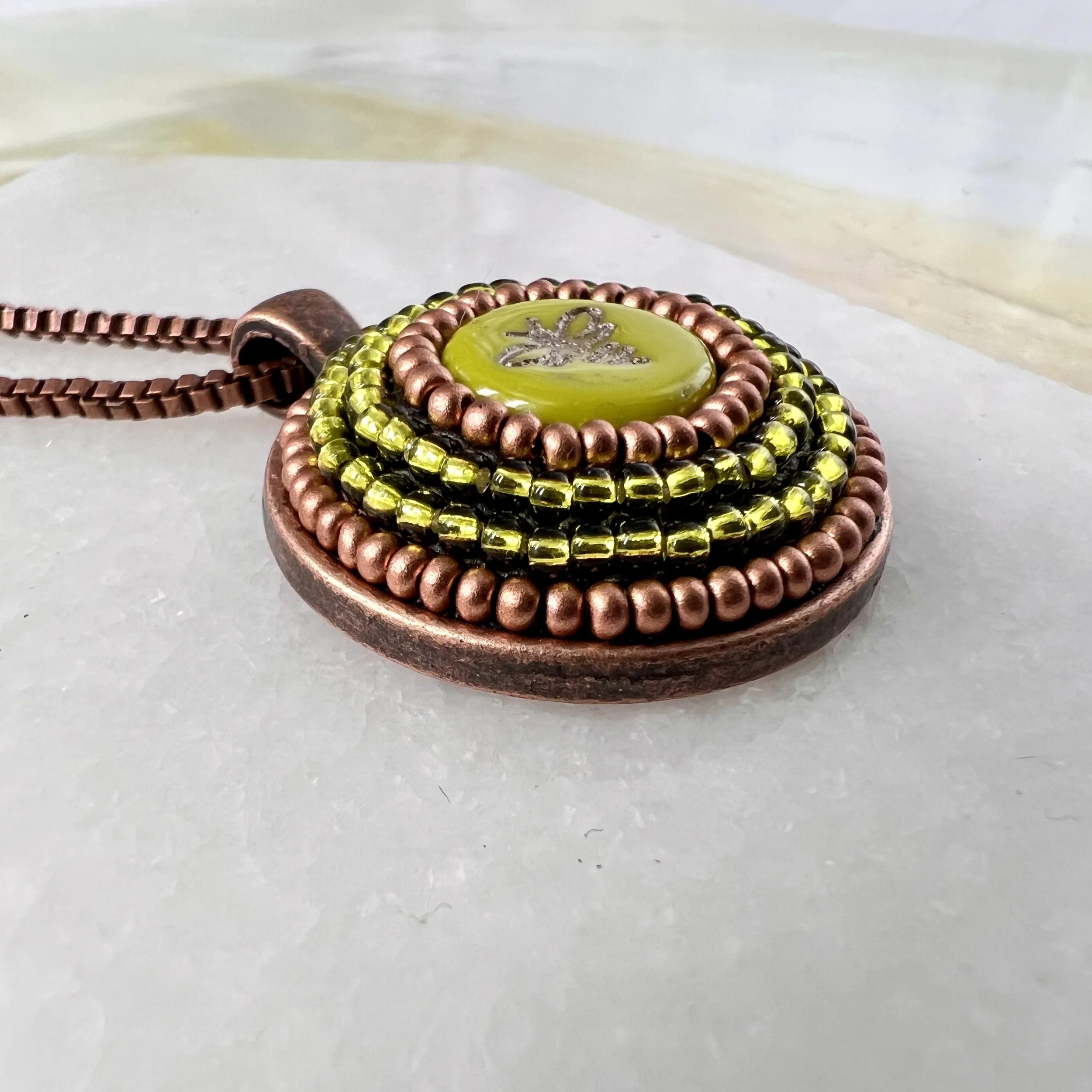 Side view of bee mosaic pendant by artist Dyanne Williams.