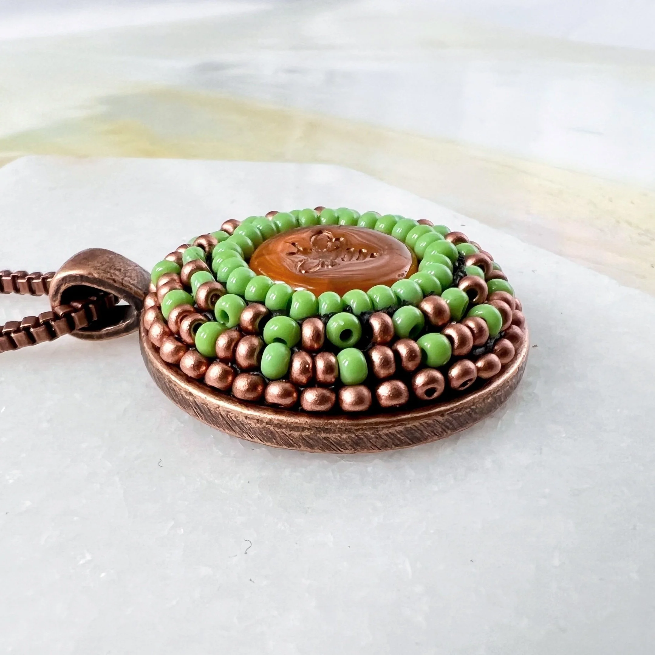 Side view of bee mosaic pendant by artist Dyanne Williams.