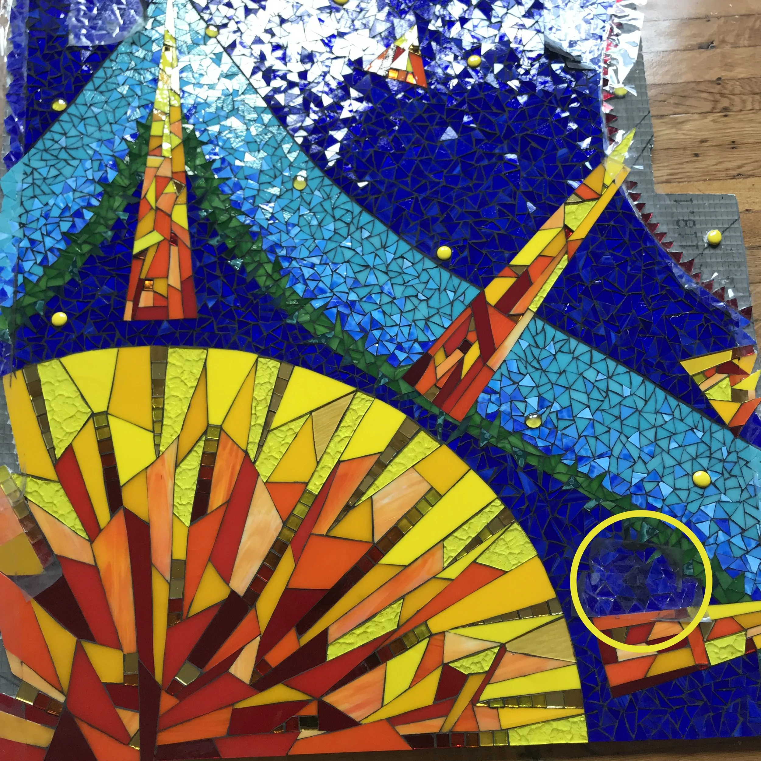 Completed & grouted panel of Sun Kitchen Mosaic with removable section for washer circled in yellow.