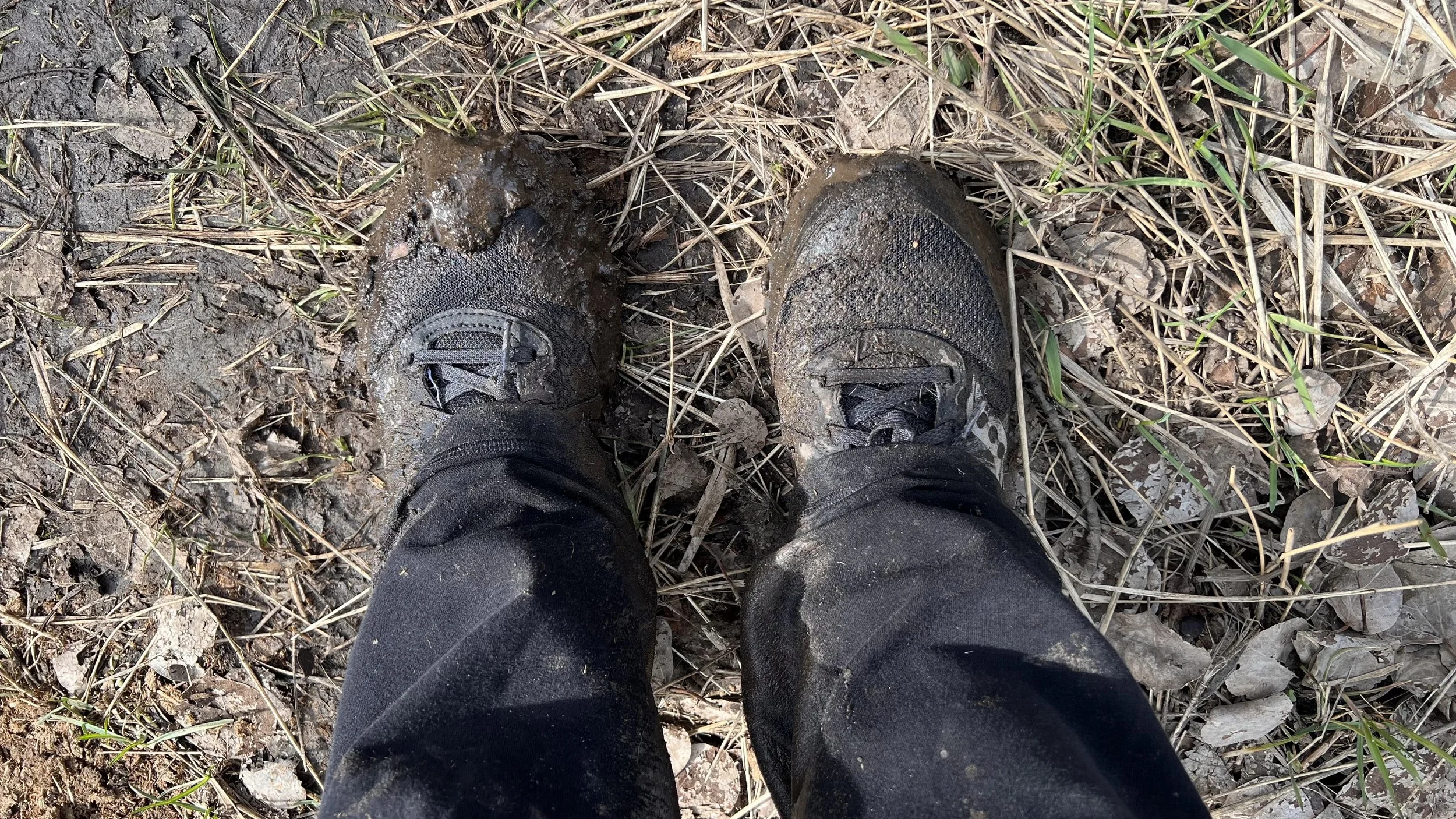 Muddy hiking boots on a trail near Ellensburg, Washington during the Cycles public art mosaic installation visit by Dyanne Williams