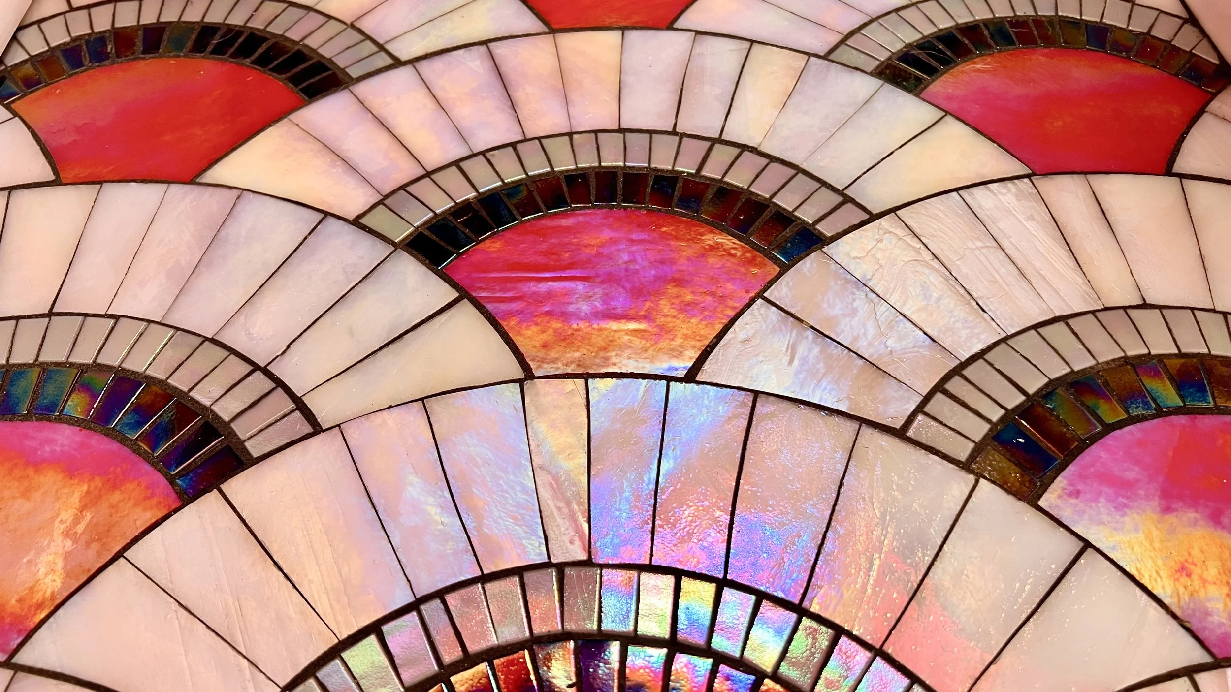 Close-up of Art Deco stained glass mosaic floor in magenta, pink, and white scallop pattern