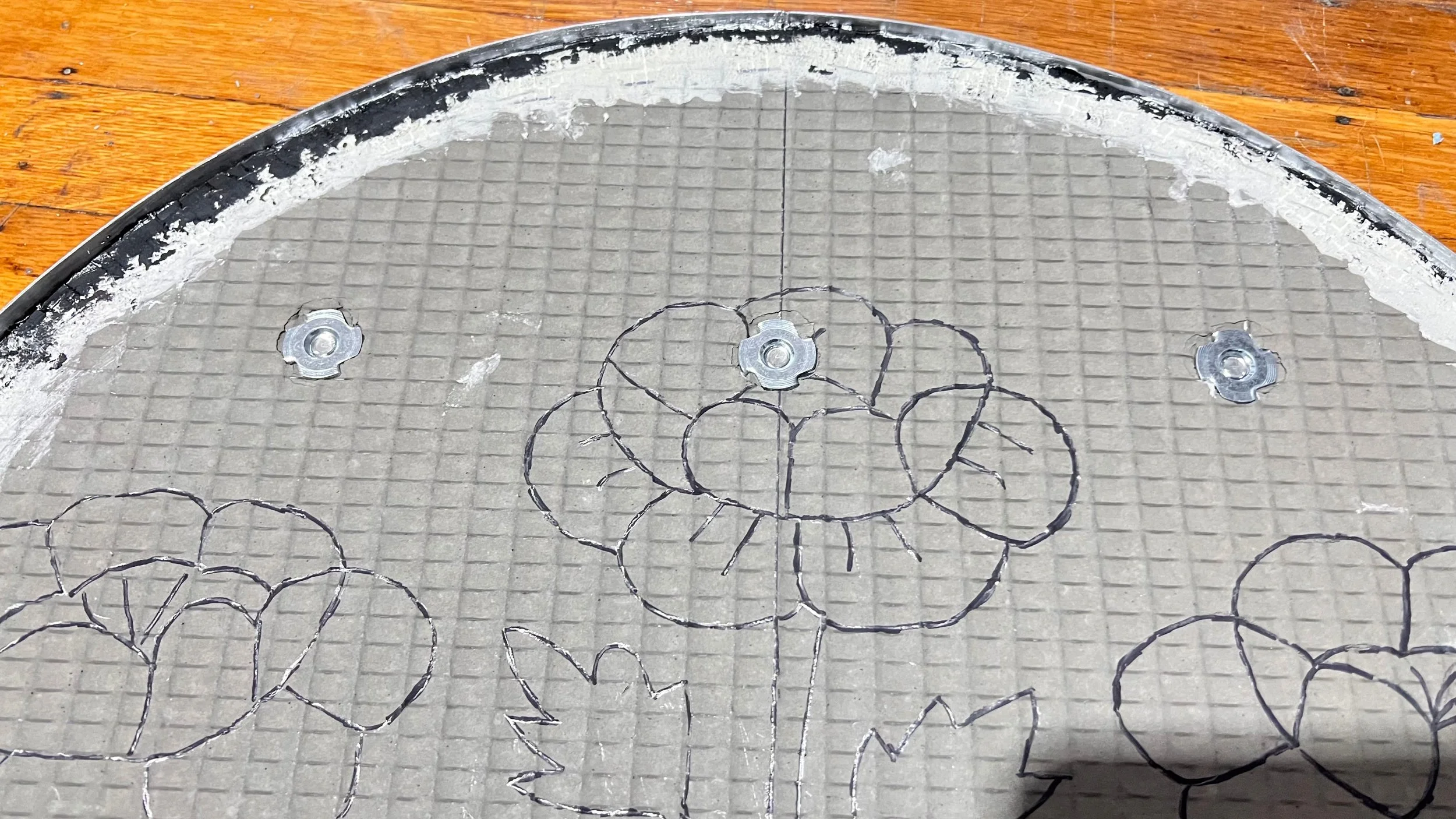Front view of washers securing French cleats to a mosaic panel for the Cycles public art installation by Dyanne Williams