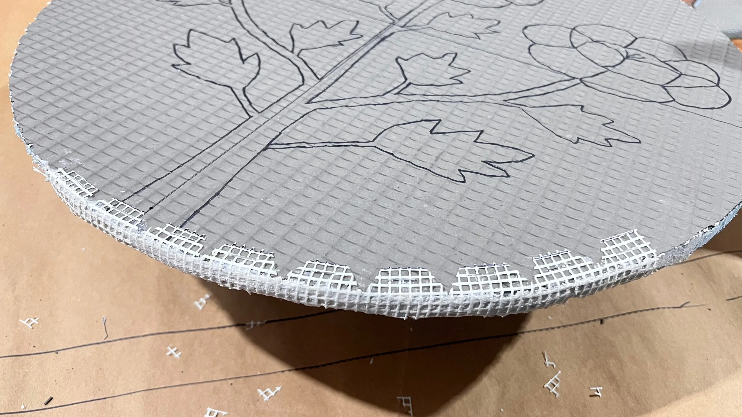 Fiberglass mesh being attached to the edge of a Wedi board circle for the Cycles public art mosaic panels by Dyanne Williams