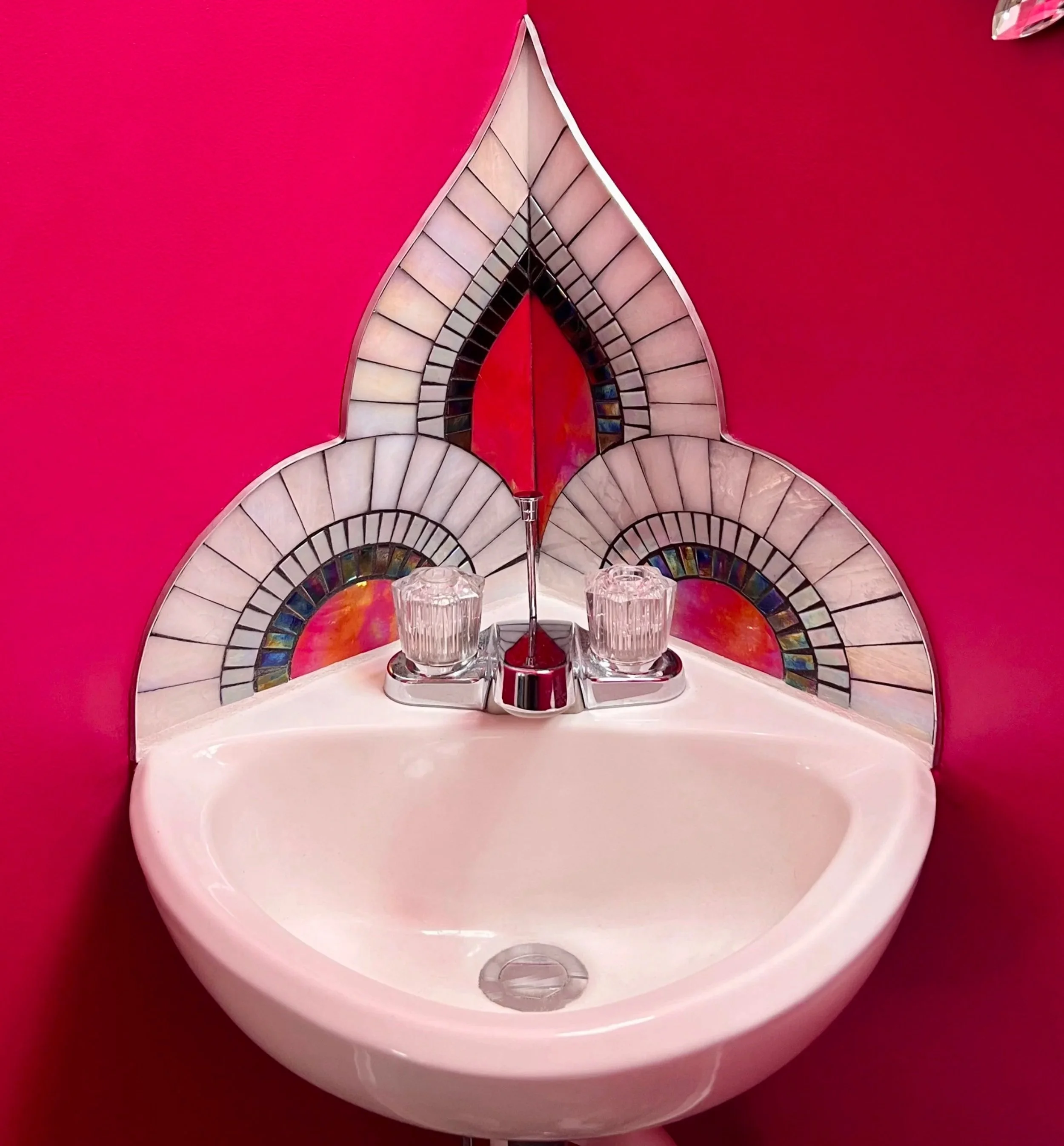 Art Deco stained glass mosaic backsplash with scallops and spire above pedestal sink