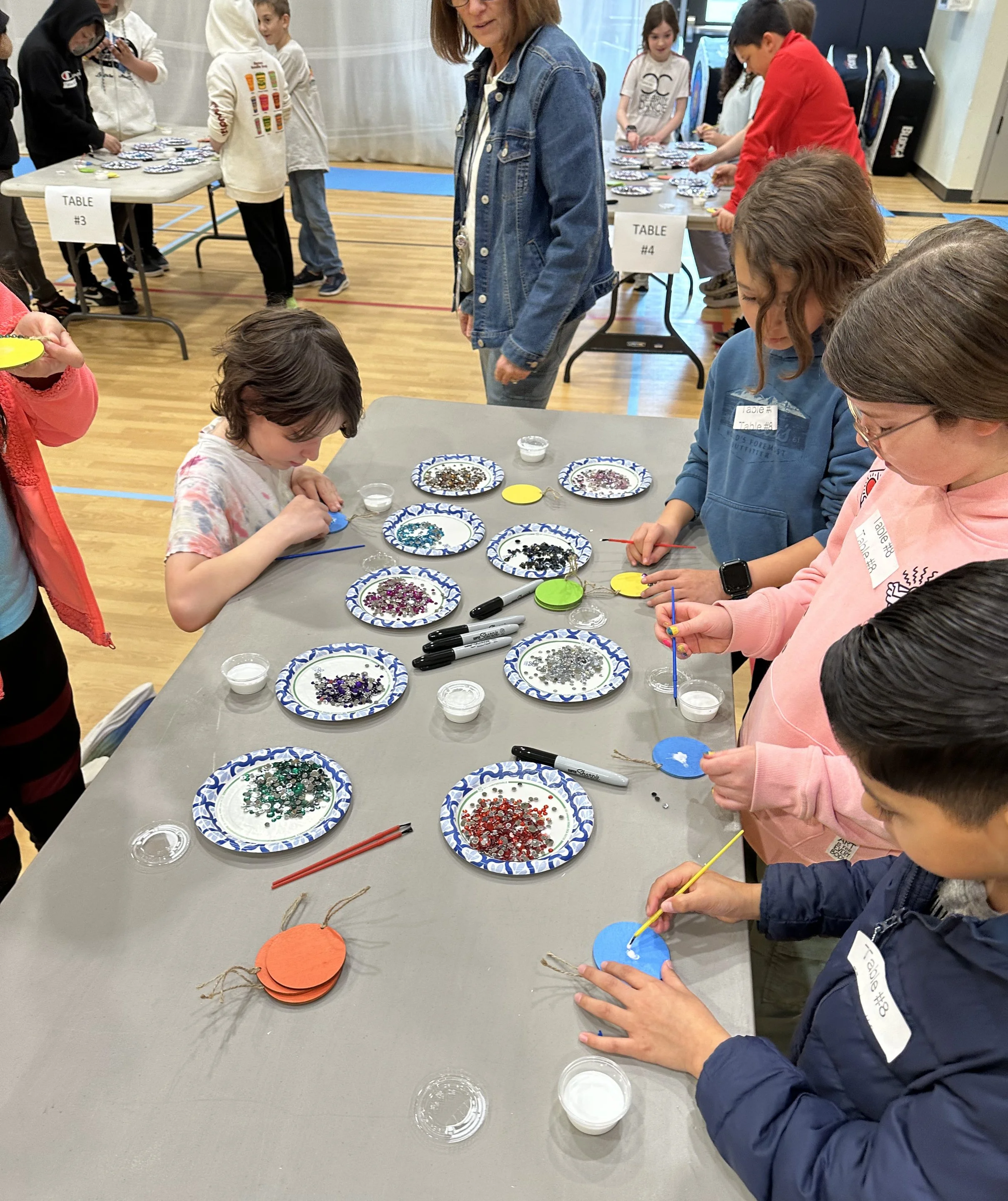 Students creating a gem mosaic medallion during the Cycles public art commission participation project at Ida Nason Aronica Elementary School in Ellensburg, Washington