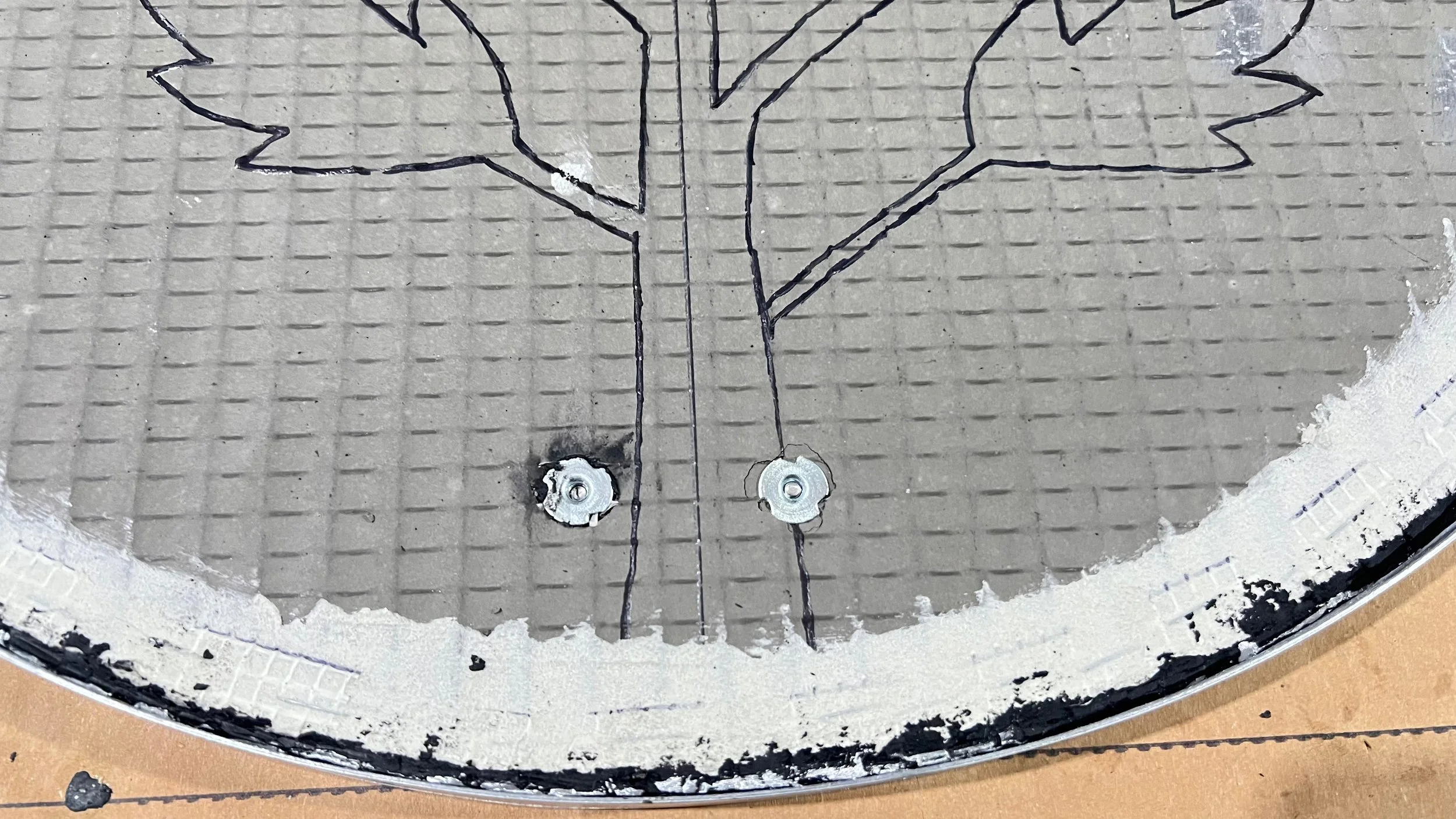Front view of washers securing anti-theft hanging hardware to a mosaic panel for the Cycles public art installation by Dyanne Williams